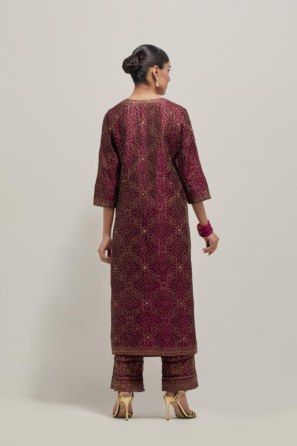 Maroon silk straight kurta set with hand embroidered sequins on bandhani inspired jaal all-over the kurta, highlighted with contrast-colored beads.