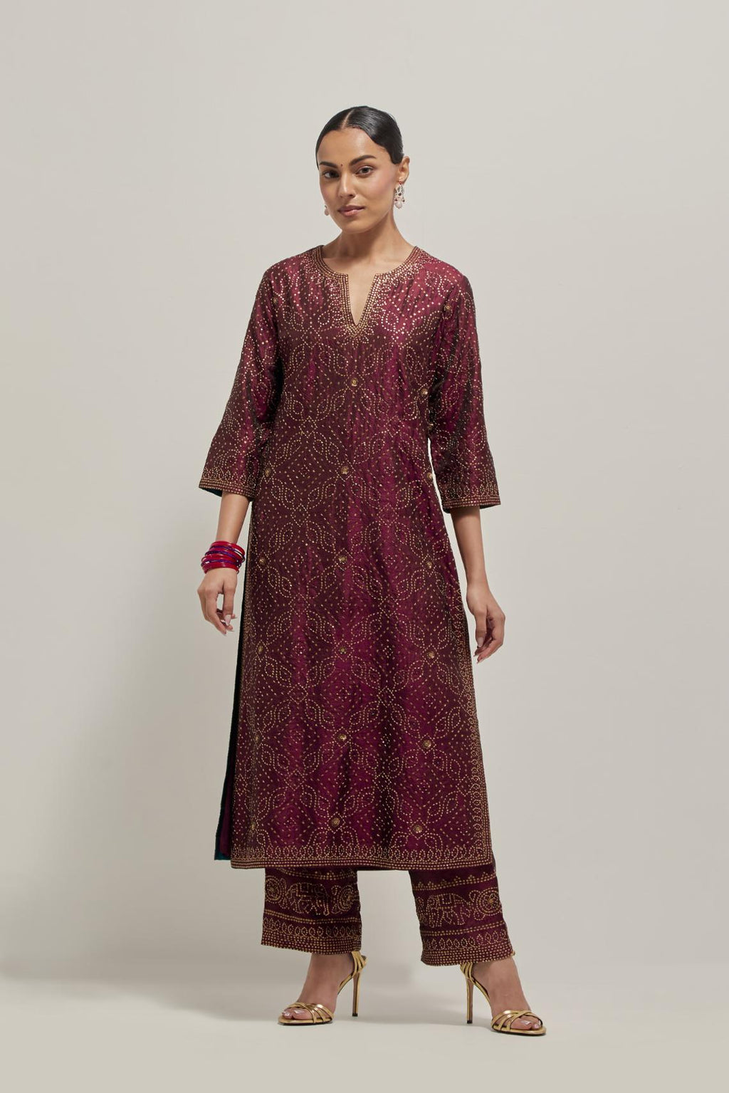 Maroon silk straight kurta set with hand embroidered sequins on bandhani inspired jaal all-over the kurta, highlighted with contrast-colored beads.
