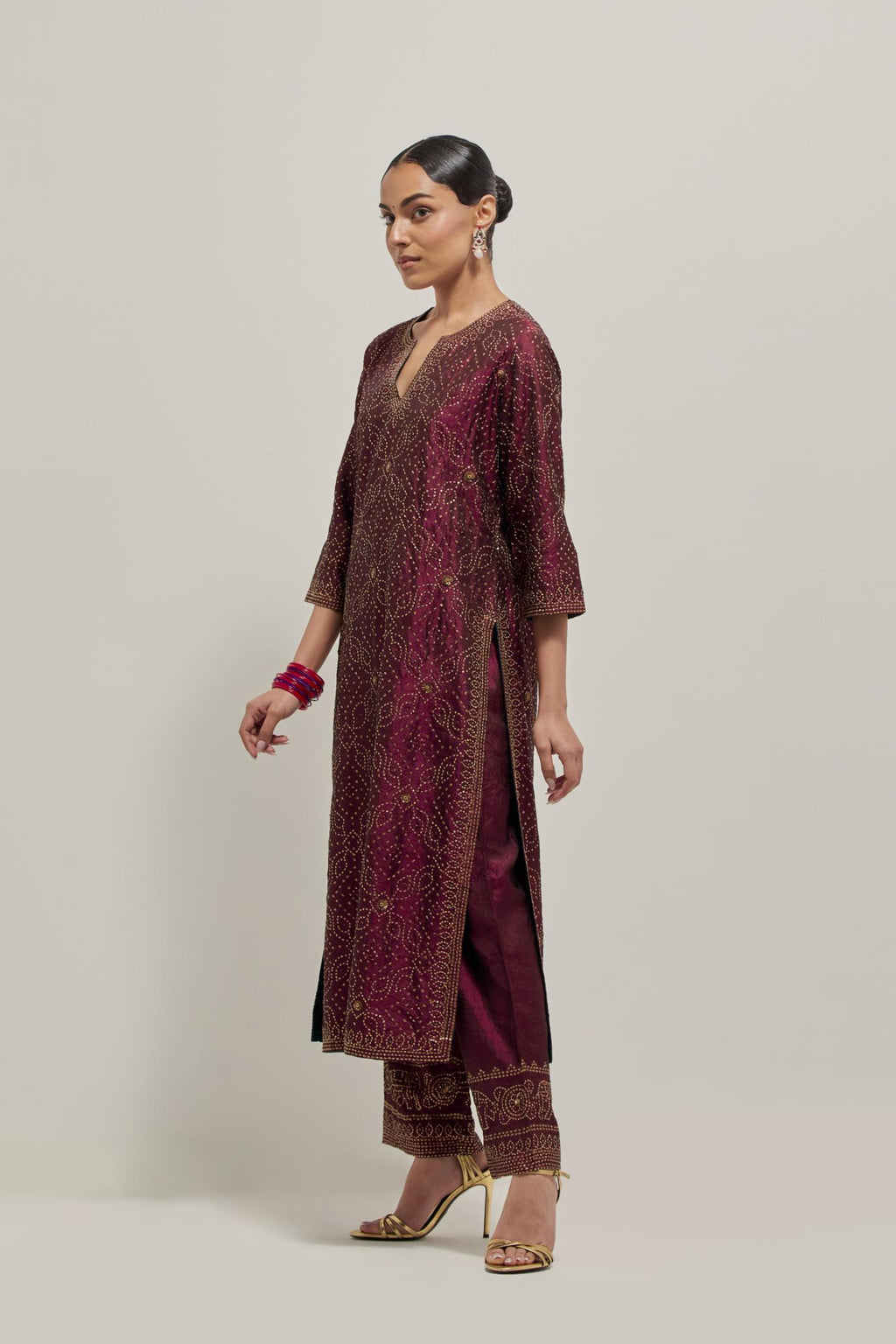 Maroon silk straight kurta set with hand embroidered sequins on bandhani inspired jaal all-over the kurta, highlighted with contrast-colored beads.