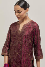 Maroon silk straight kurta set with hand embroidered sequins on bandhani inspired jaal all-over the kurta, highlighted with contrast-colored beads.