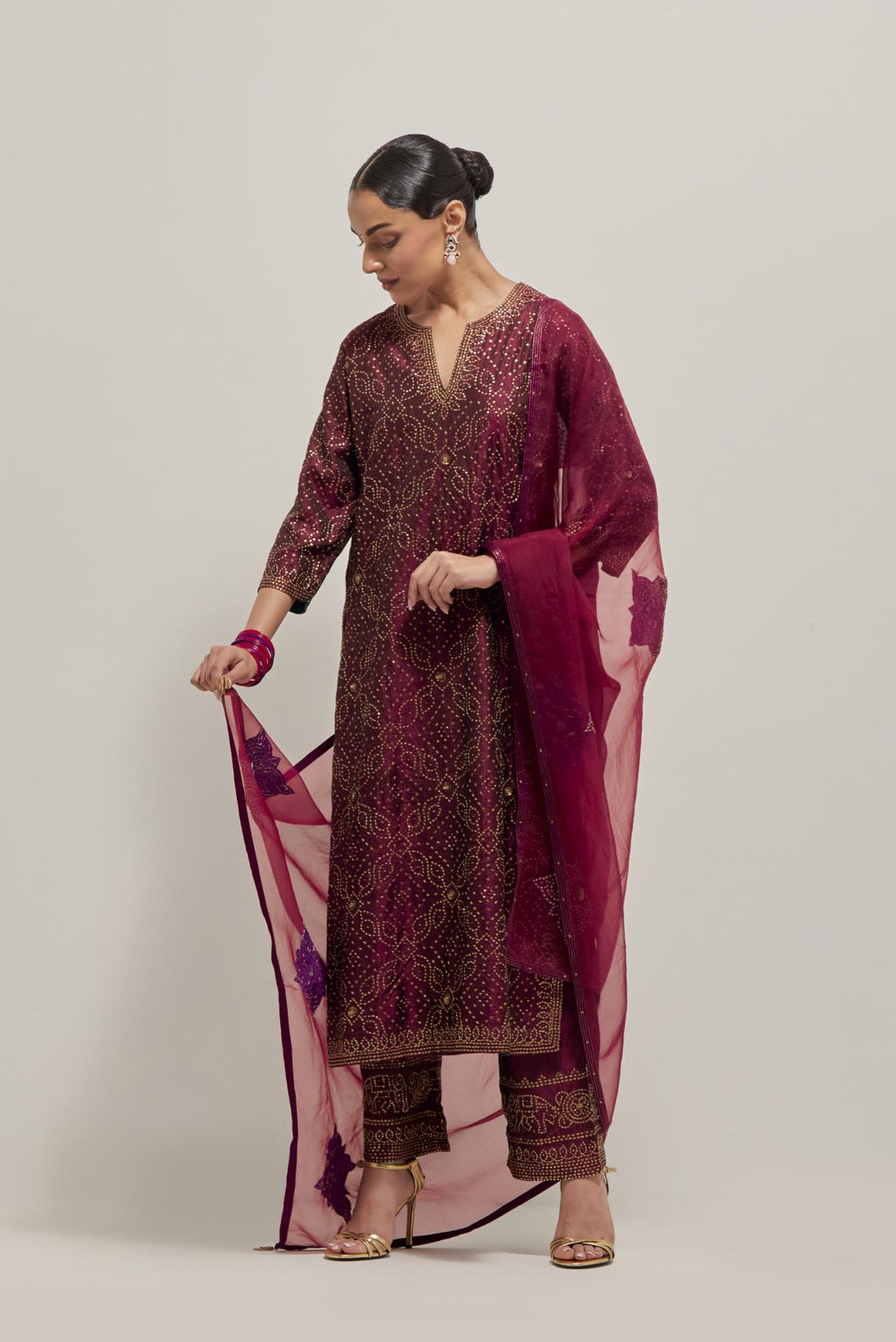 Maroon silk straight kurta set with hand embroidered sequins on bandhani inspired jaal all-over the kurta, highlighted with contrast-colored beads.