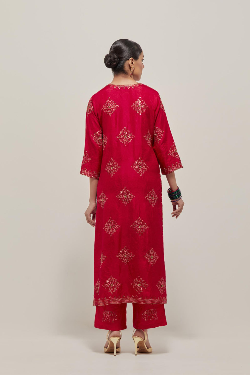 Red silk straight kurta set with all-over hand embroidered sequins on bandhani inspired motifs, highlighted with contrast-colored beads.