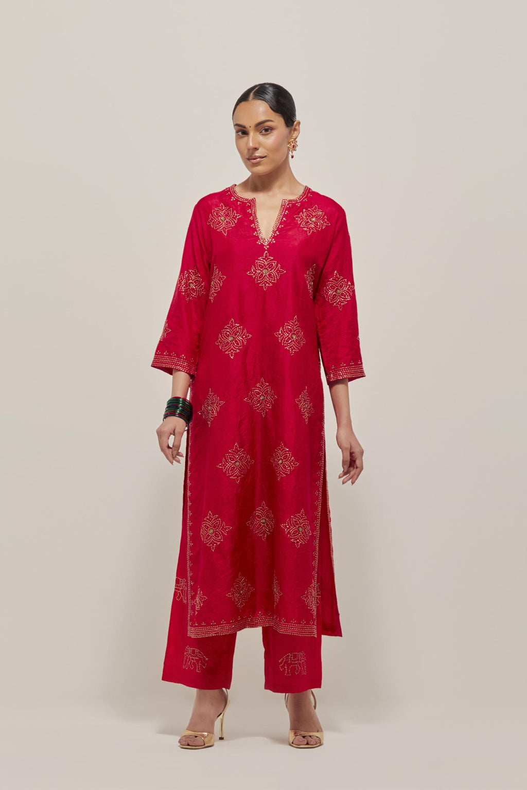 Red silk straight kurta set with all-over hand embroidered sequins on bandhani inspired motifs, highlighted with contrast-colored beads.