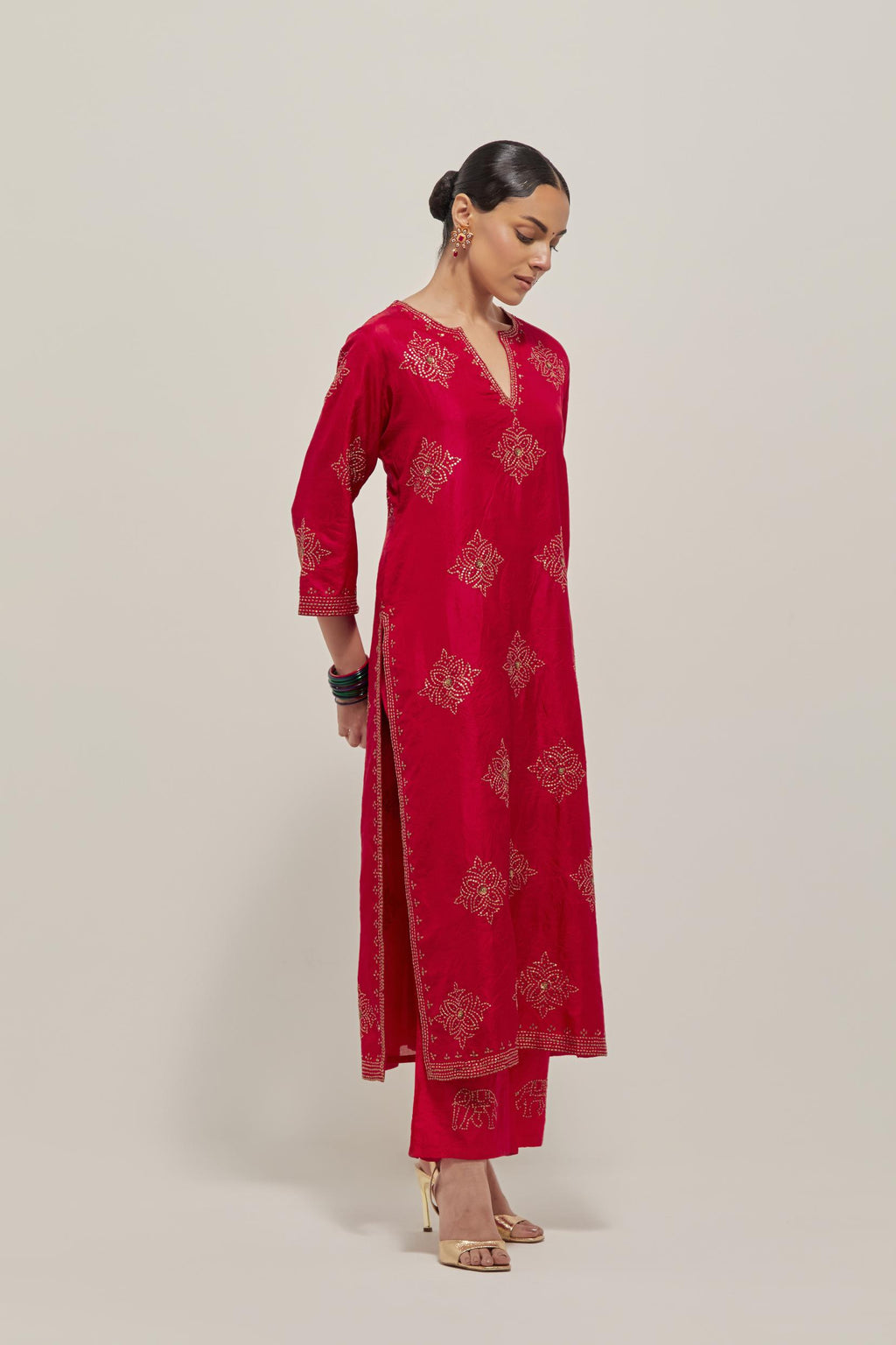 Red silk straight kurta set with all-over hand embroidered sequins on bandhani inspired motifs, highlighted with contrast-colored beads.