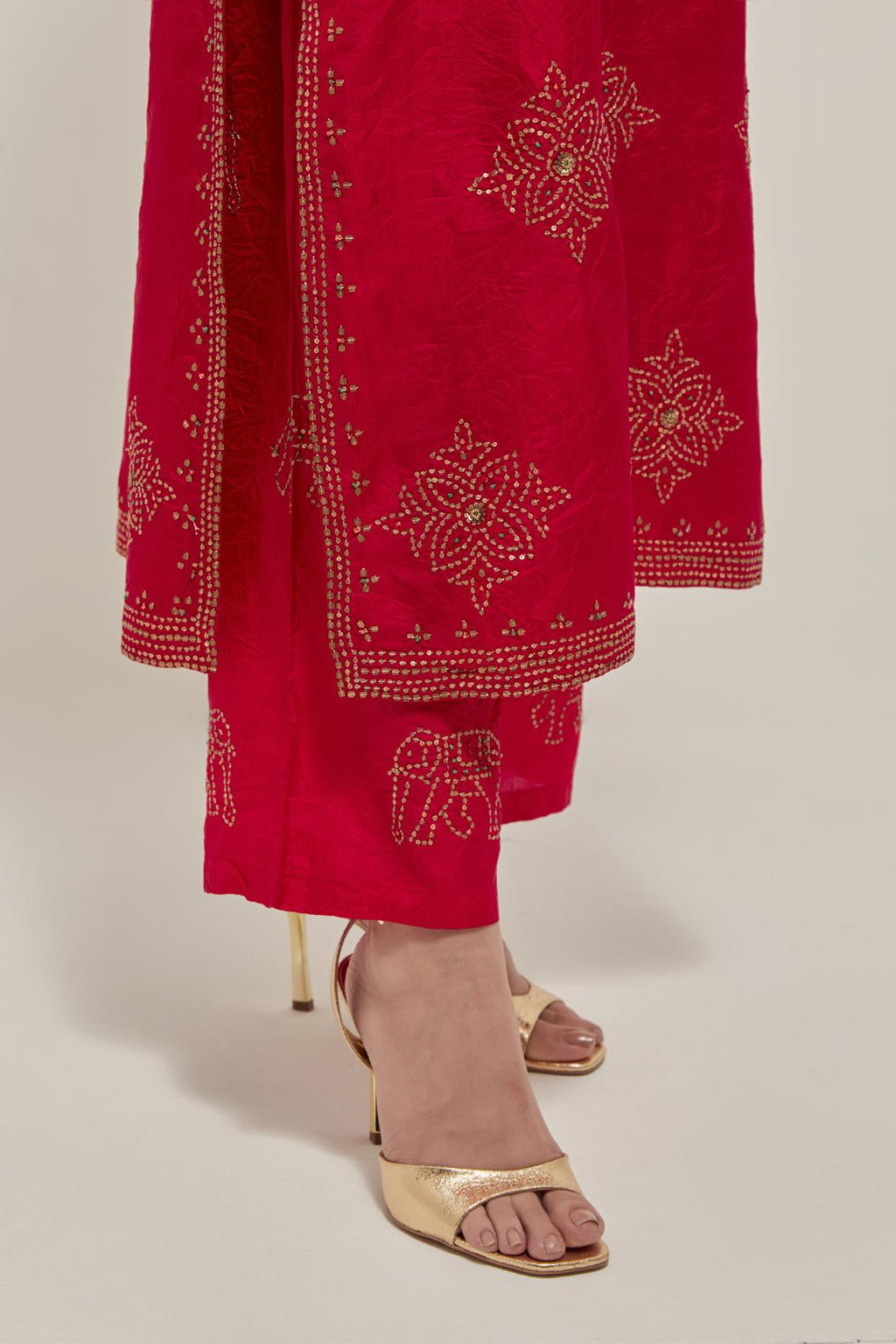 Red silk straight kurta set with all-over hand embroidered sequins on bandhani inspired motifs, highlighted with contrast-colored beads.