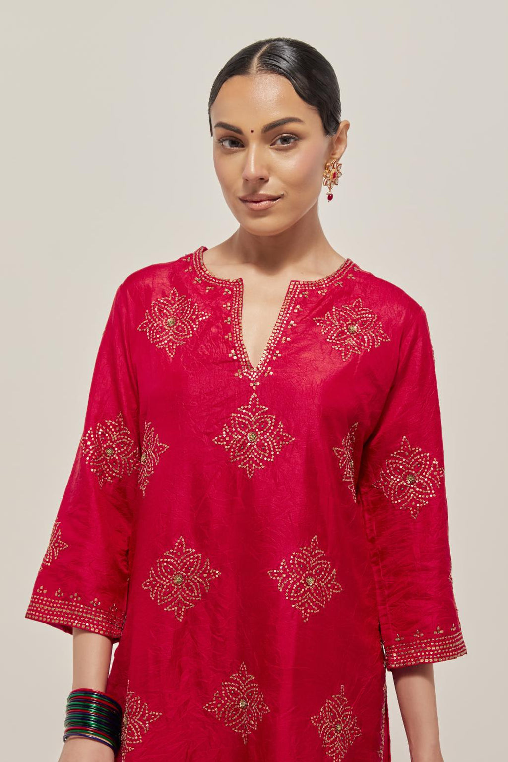 Red silk straight kurta set with all-over hand embroidered sequins on bandhani inspired motifs, highlighted with contrast-colored beads.