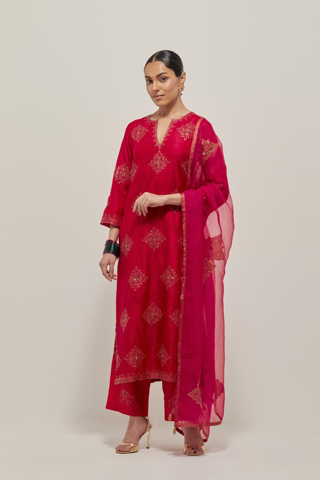 Red silk straight kurta set with all-over hand embroidered sequins on bandhani inspired motifs, highlighted with contrast-colored beads.