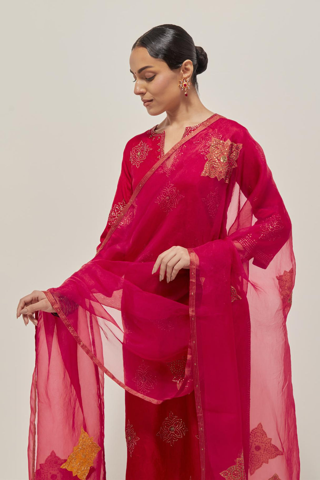 Red silk straight kurta set with all-over hand embroidered sequins on bandhani inspired motifs, highlighted with contrast-colored beads.