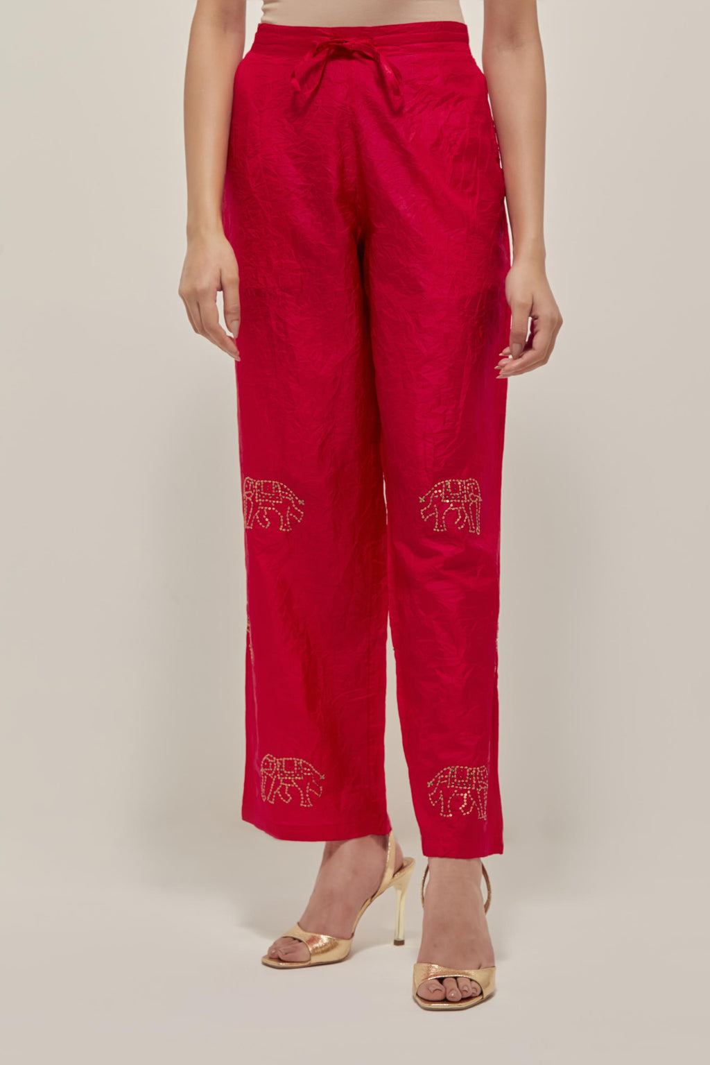 Red silk pants with side pockets and assorted sequined elephants till mid-calf length.