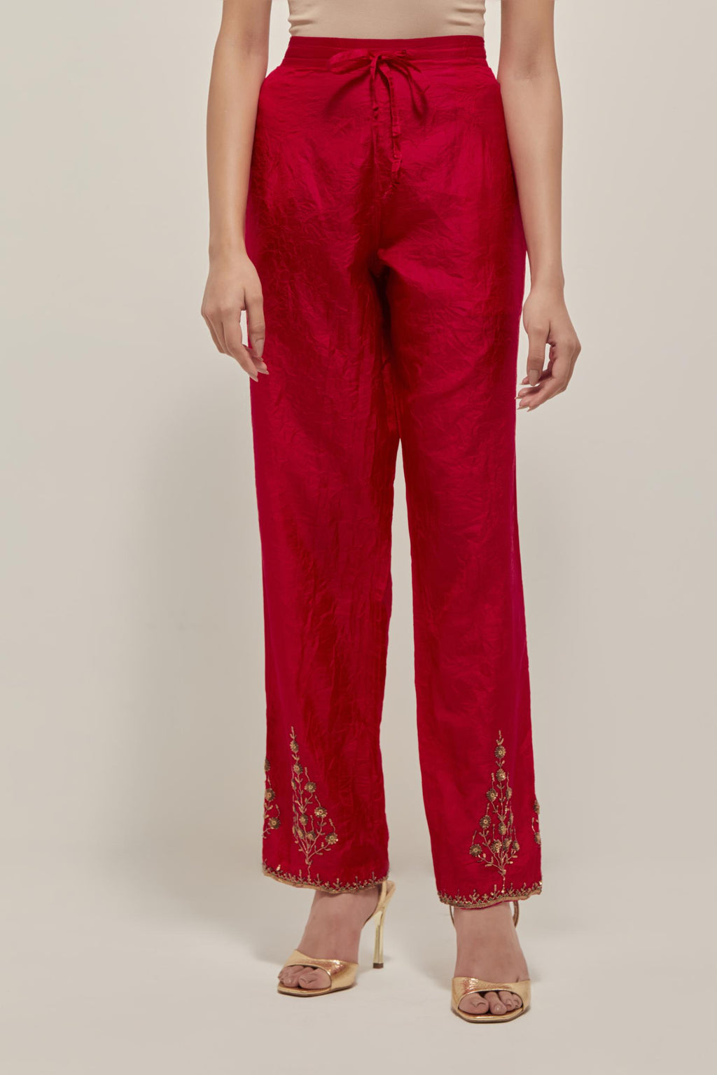 Red Silk pants, highlighted with hand embroidered bead, sequins and zardozi boota at hem, highlighted with contrast bead work.