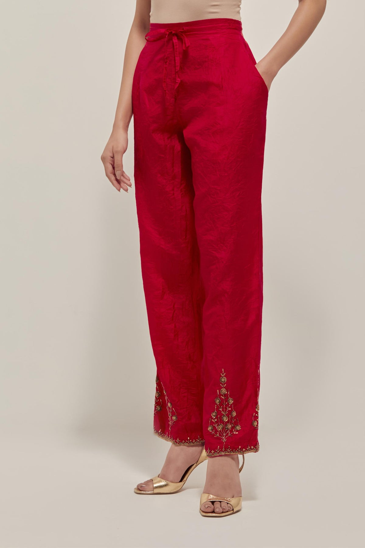 Red Silk pants, highlighted with hand embroidered bead, sequins and zardozi boota at hem, highlighted with contrast bead work.