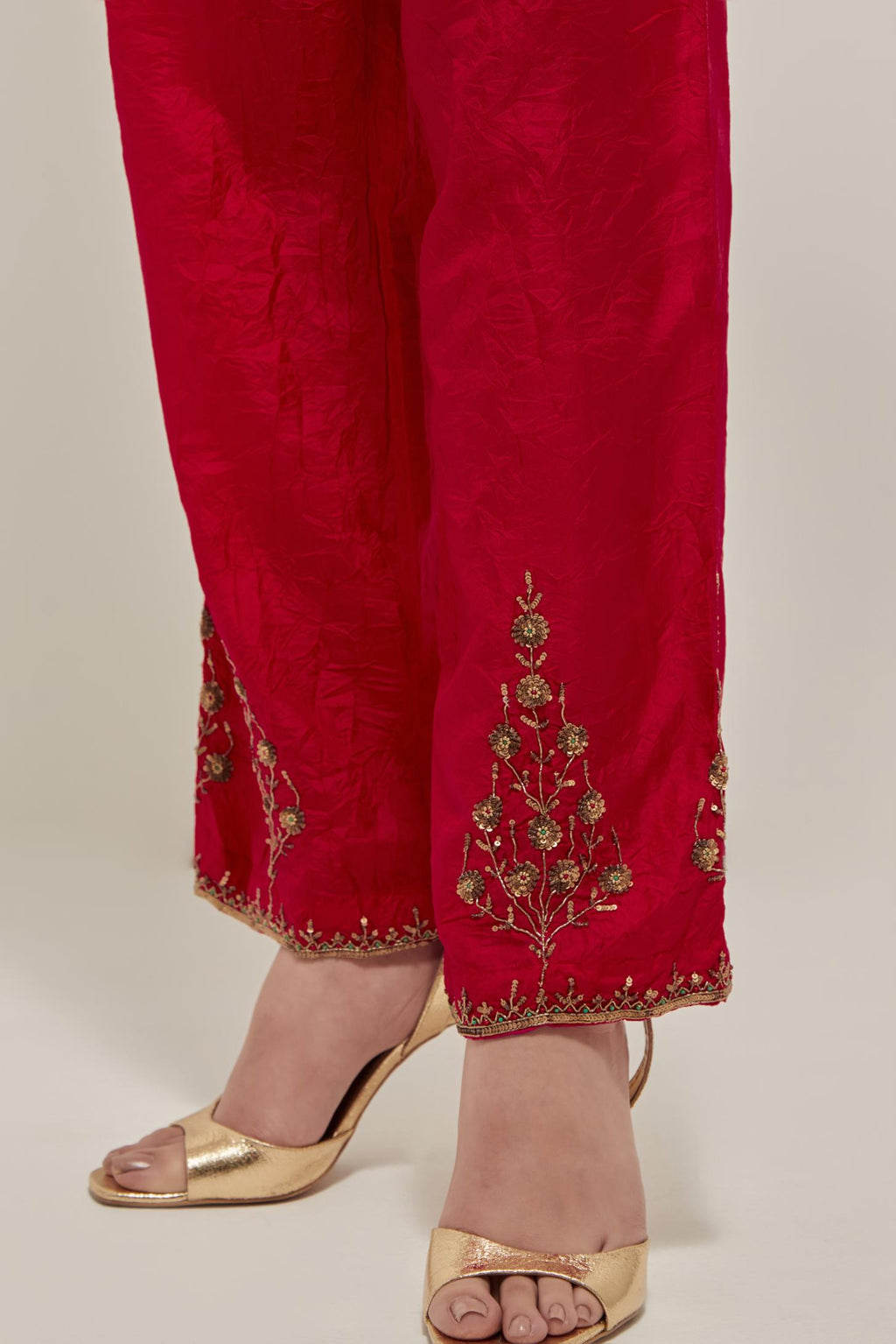Red Silk pants, highlighted with hand embroidered bead, sequins and zardozi boota at hem, highlighted with contrast bead work.