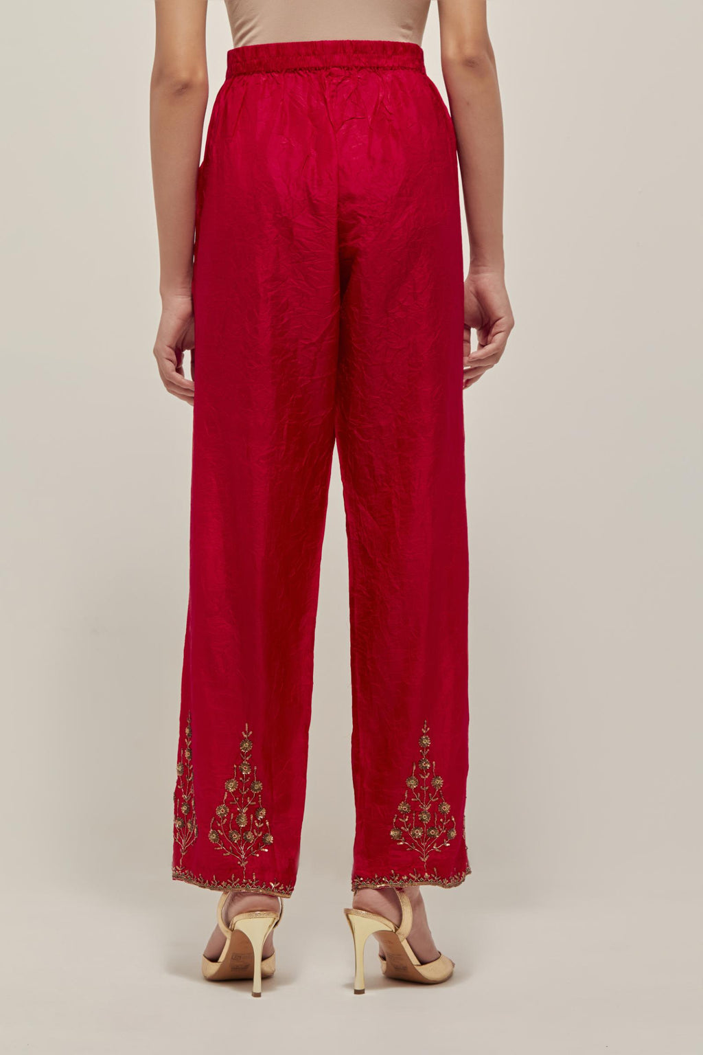 Red Silk pants, highlighted with hand embroidered bead, sequins and zardozi boota at hem, highlighted with contrast bead work.