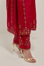 Red silk straight kurta set with round neck and slit in front. It has hand embroidered zardozi and sequins chhari stripes, all-over and heavier butas at hem, highlighted with beads.