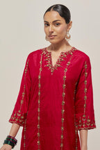 Red silk straight kurta set with round neck and slit in front. It has hand embroidered zardozi and sequins chhari stripes, all-over and heavier butas at hem, highlighted with beads.