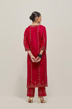 Red silk straight kurta set with round neck and slit in front. It has hand embroidered zardozi and sequins chhari stripes, all-over and heavier butas at hem, highlighted with beads.