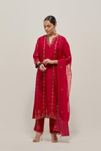 Red silk straight kurta set with round neck and slit in front. It has hand embroidered zardozi and sequins chhari stripes, all-over and heavier butas at hem, highlighted with beads.
