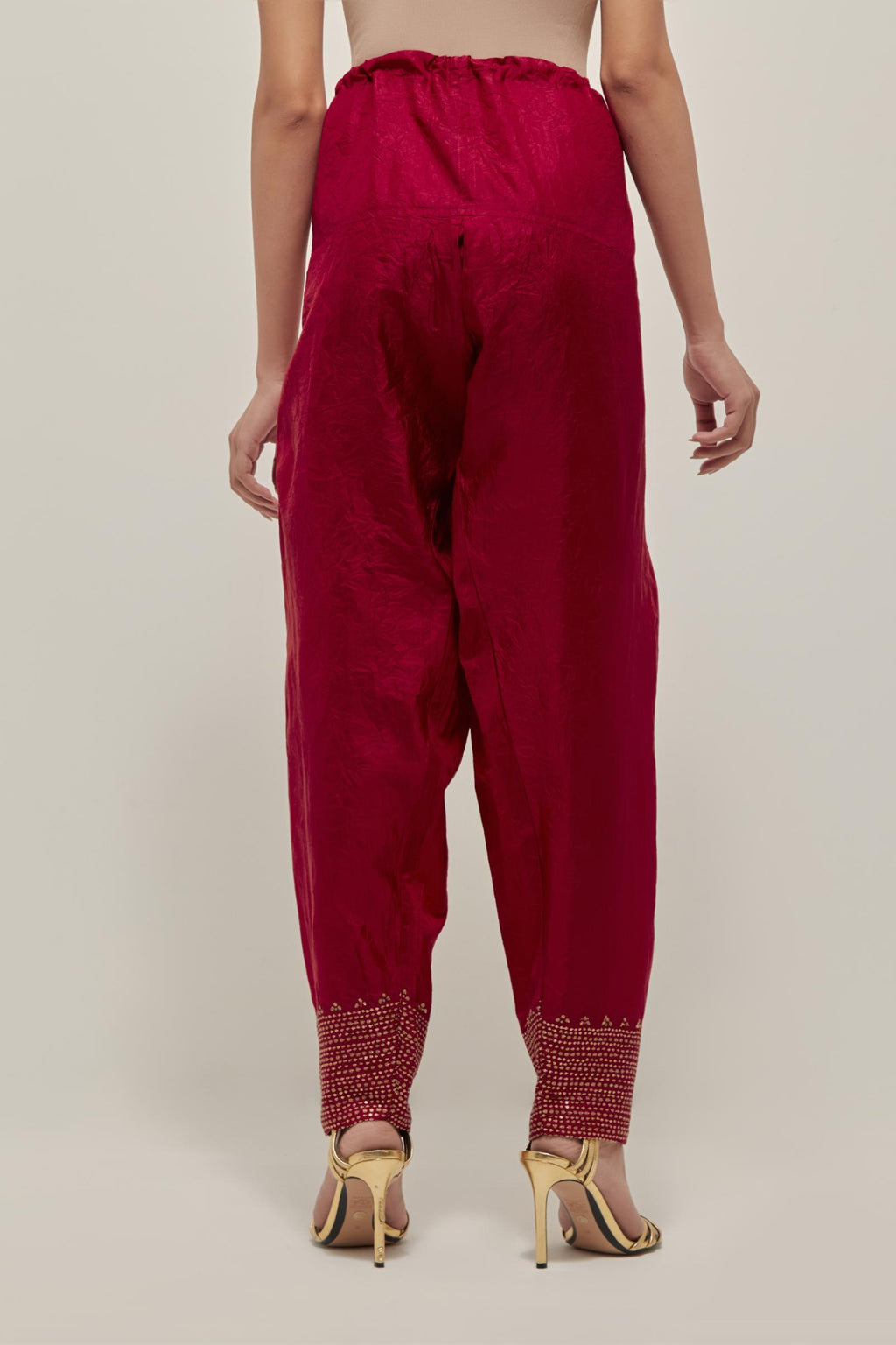 Red silk narrow salwar with a broad bandhani-inspired border at the hem, detailed with delicate bead and sequin work.