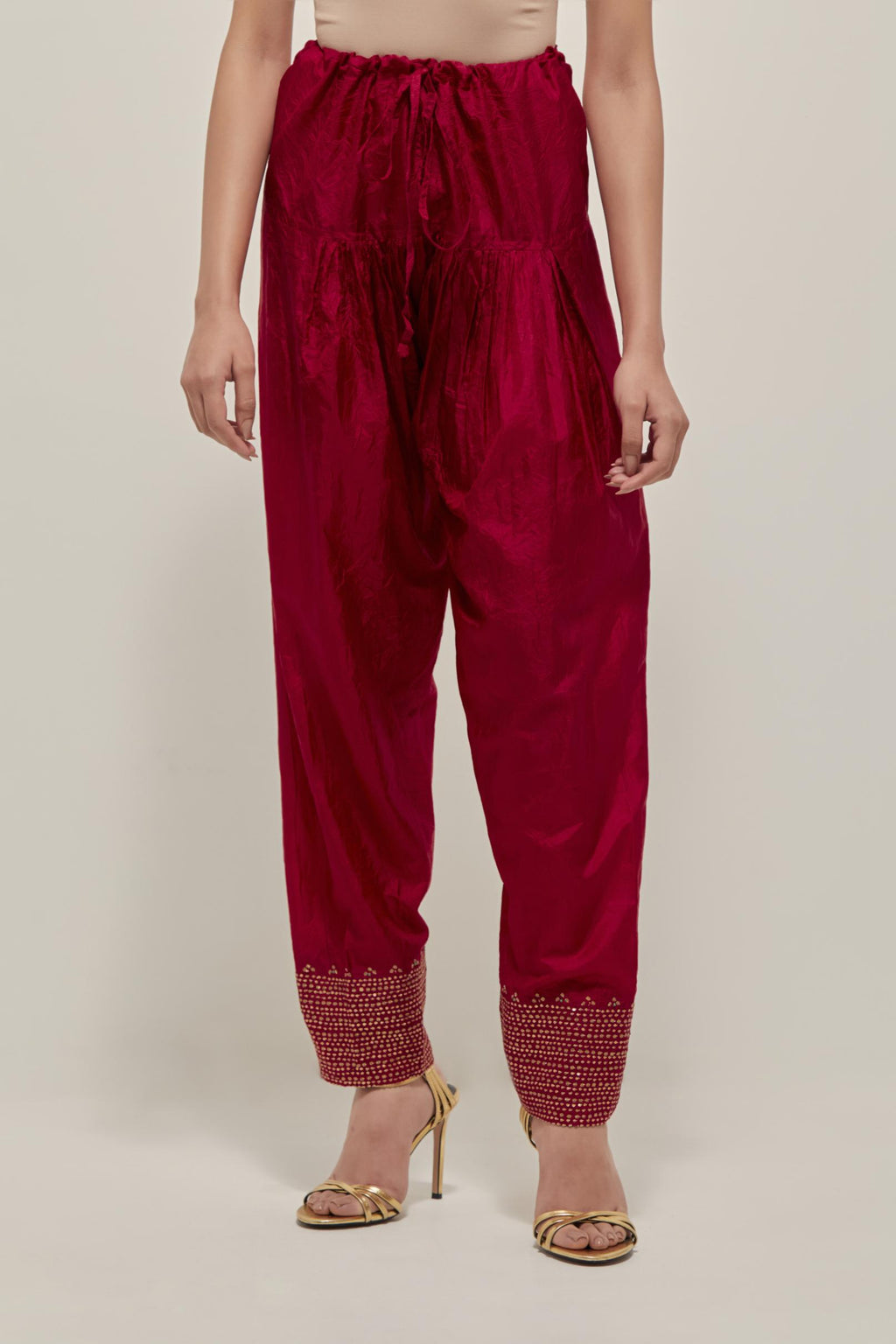 Red silk narrow salwar with a broad bandhani-inspired border at the hem, detailed with delicate bead and sequin work.