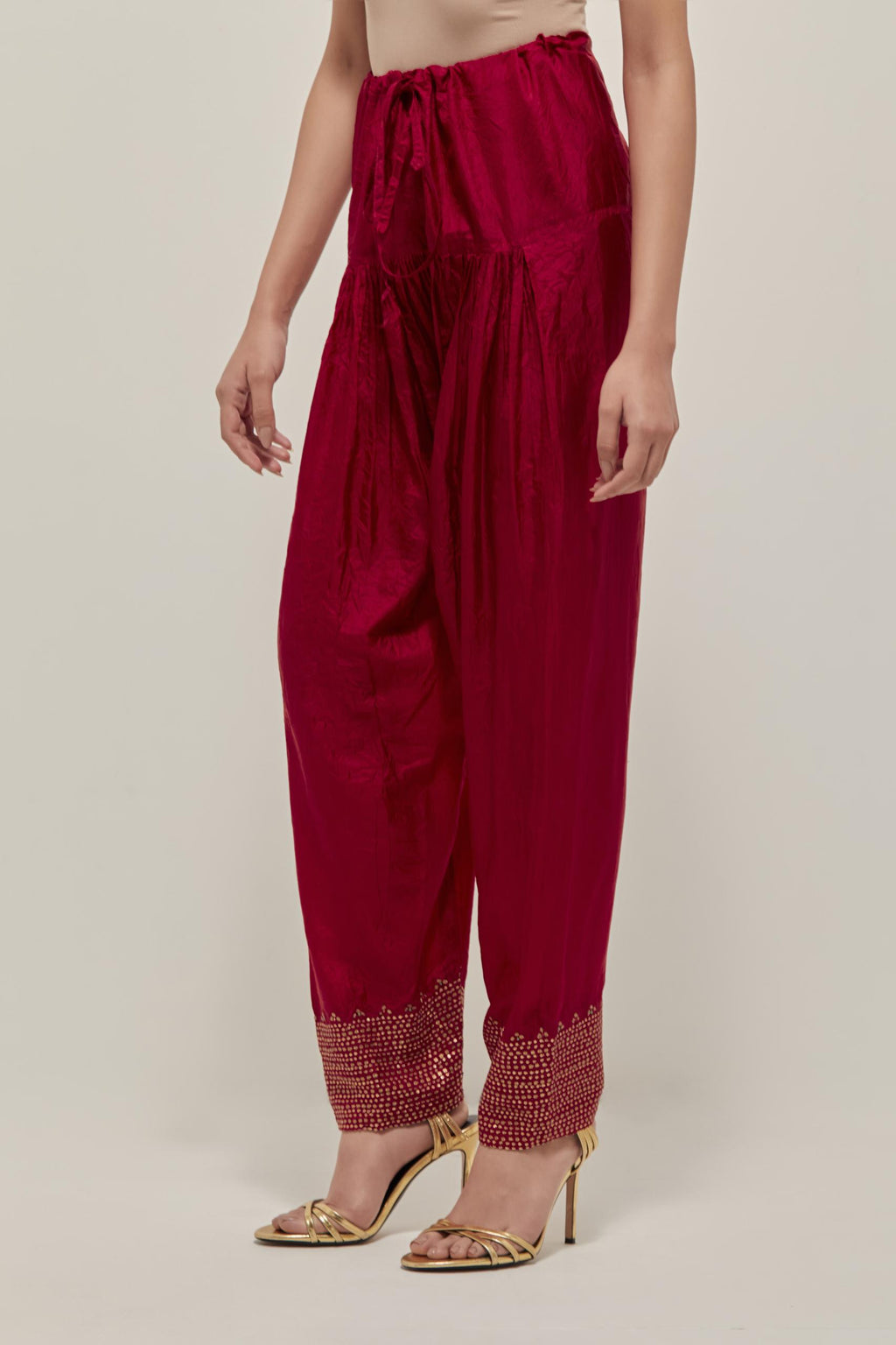 Red silk narrow salwar with a broad bandhani-inspired border at the hem, detailed with delicate bead and sequin work.