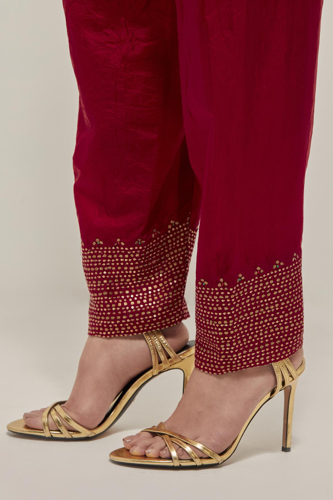 Red silk narrow salwar with a broad bandhani-inspired border at the hem, detailed with delicate bead and sequin work.