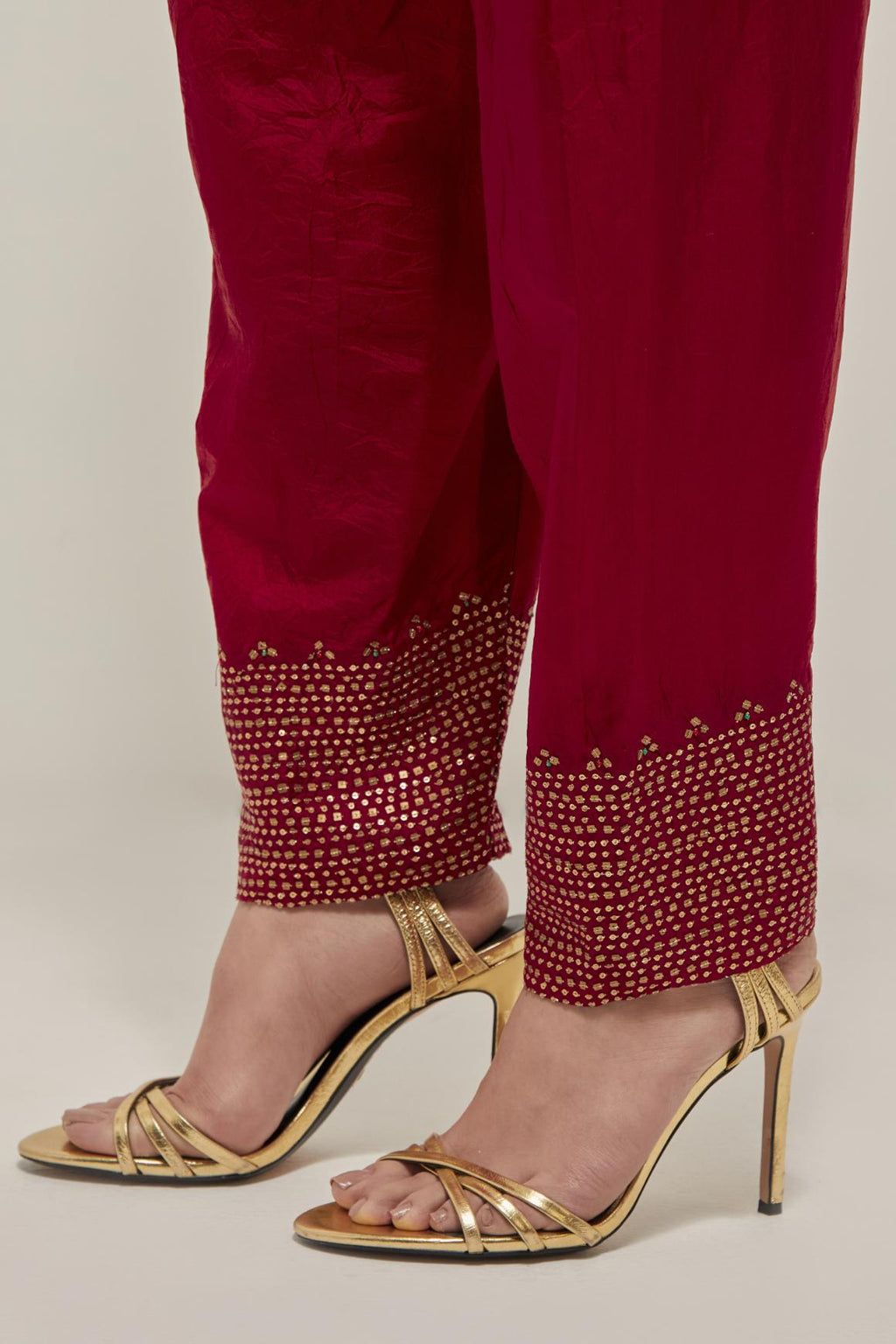 Red silk narrow salwar with a broad bandhani-inspired border at the hem, detailed with delicate bead and sequin work.