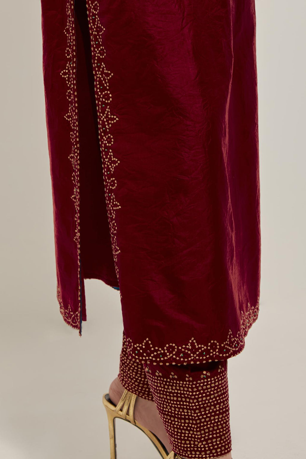 Red Silk kurta set with hand embroidered sequins on bandhani inspired jaal work at neck, hem and sleeves cuff, highlighted with contrast-colored beads.