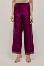 Wine silk pants with a narrow bandhani-inspired border at the hem, detailed with delicate bead and sequin work.