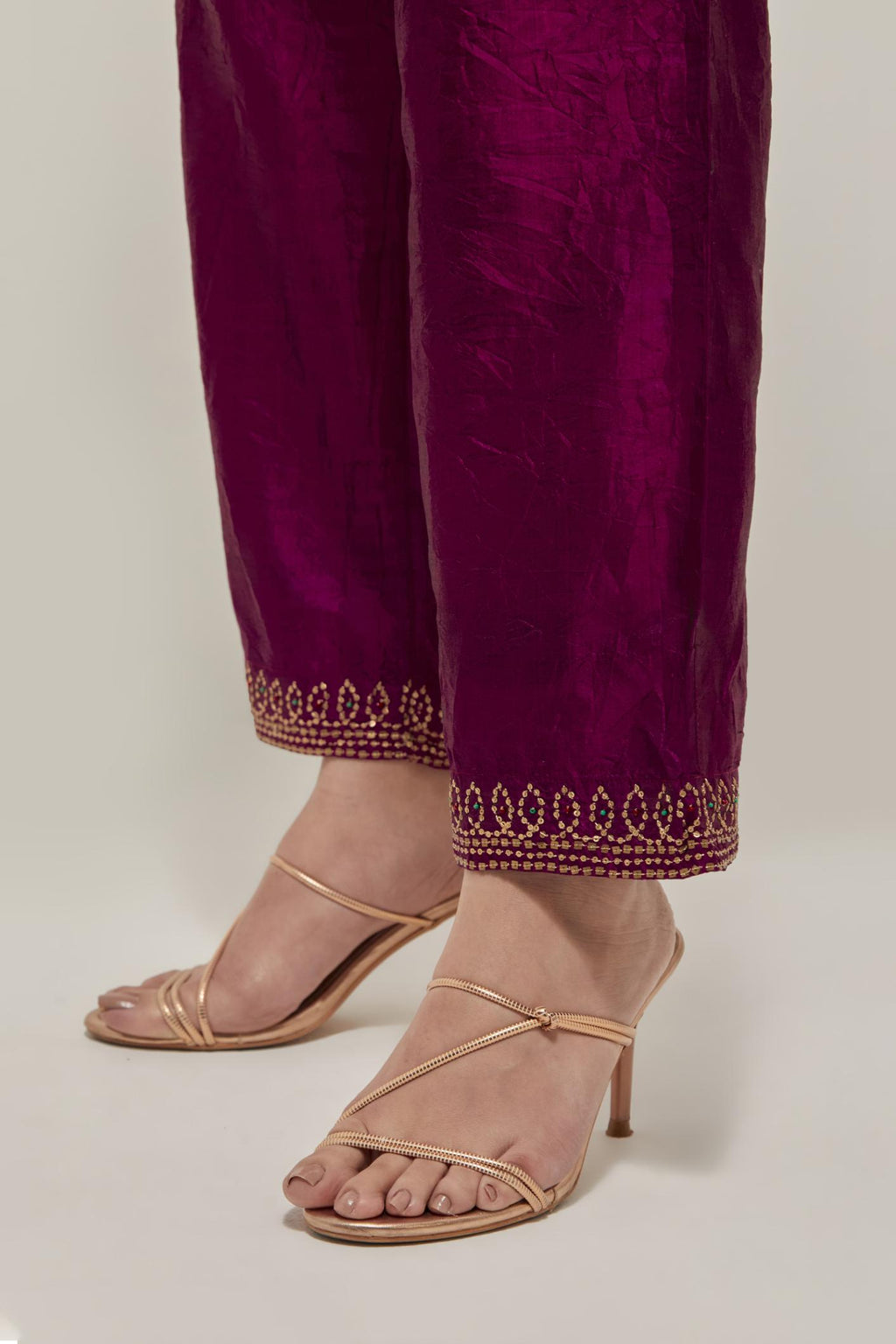 Wine silk pants with a narrow bandhani-inspired border at the hem, detailed with delicate bead and sequin work.