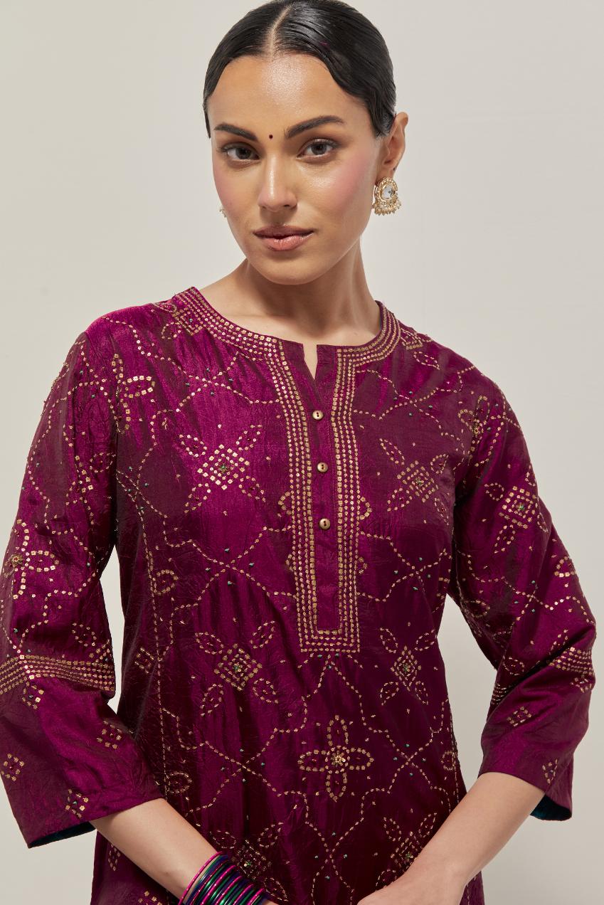 Wine Silk kurta set with all-over hand embroidered sequins on bandhani inspired floral jaal and small square booti at side panels, highlighted with contrast-colored beads.
