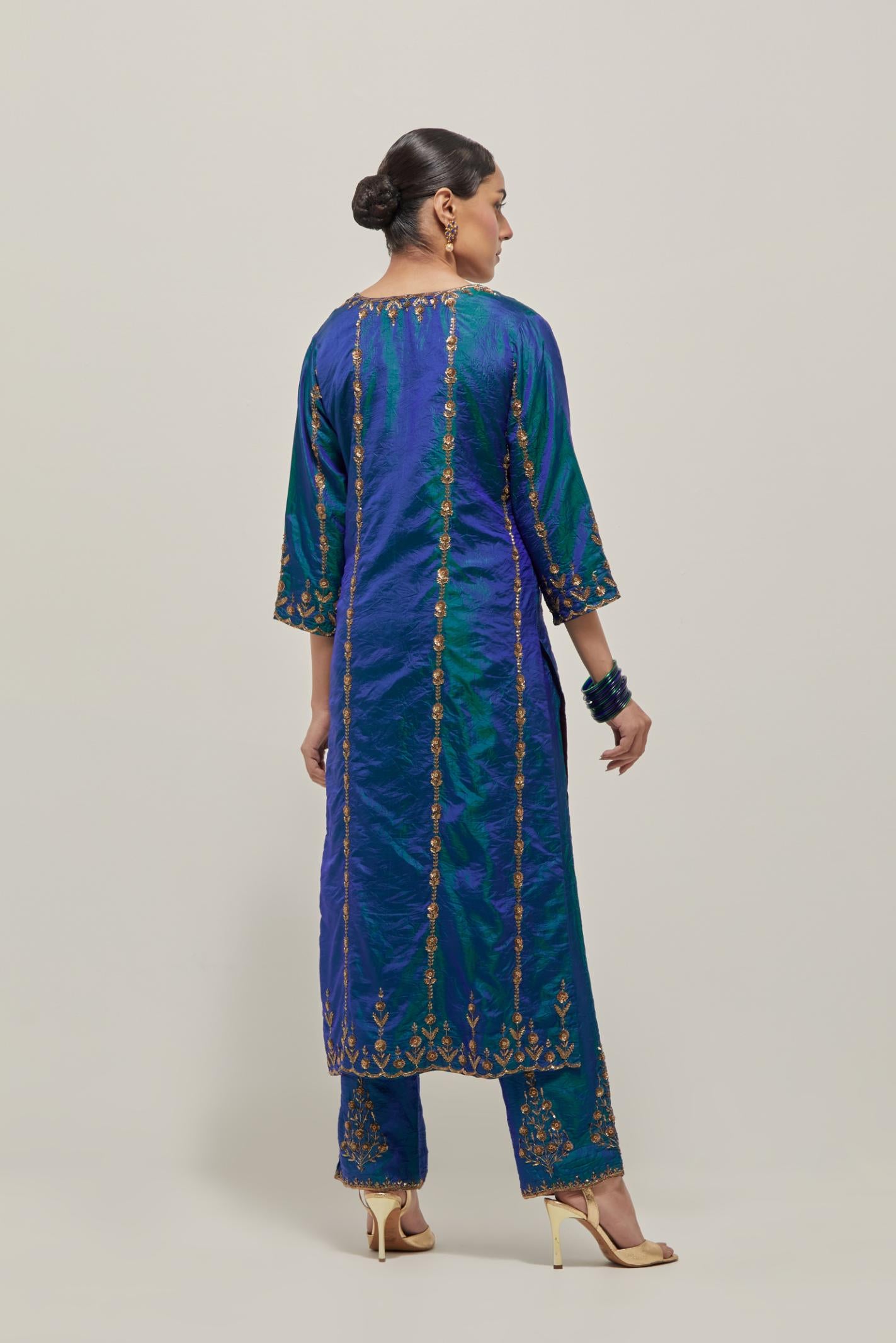 Teal Blue silk straight kurta set with round neck and slit in front. It has hand embroidered zardozi and sequins chhari stripes, all-over and heavier butas at hem, highlighted with beads.