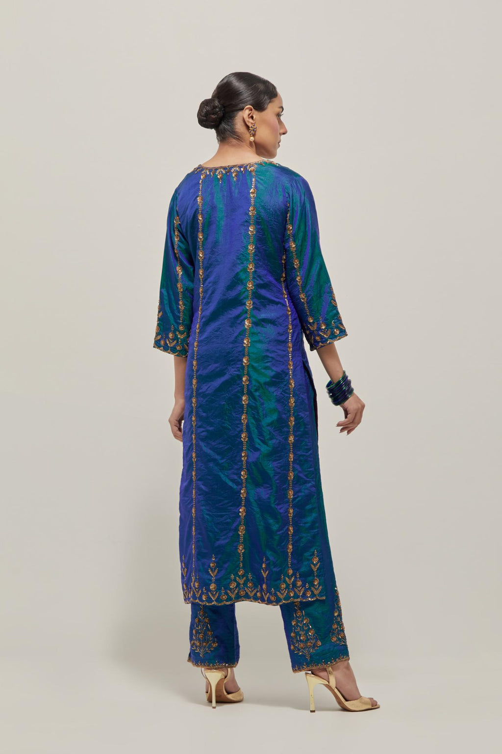 Teal Blue silk straight kurta set with round neck and slit in front. It has hand embroidered zardozi and sequins chhari stripes, all-over and heavier butas at hem, highlighted with beads.