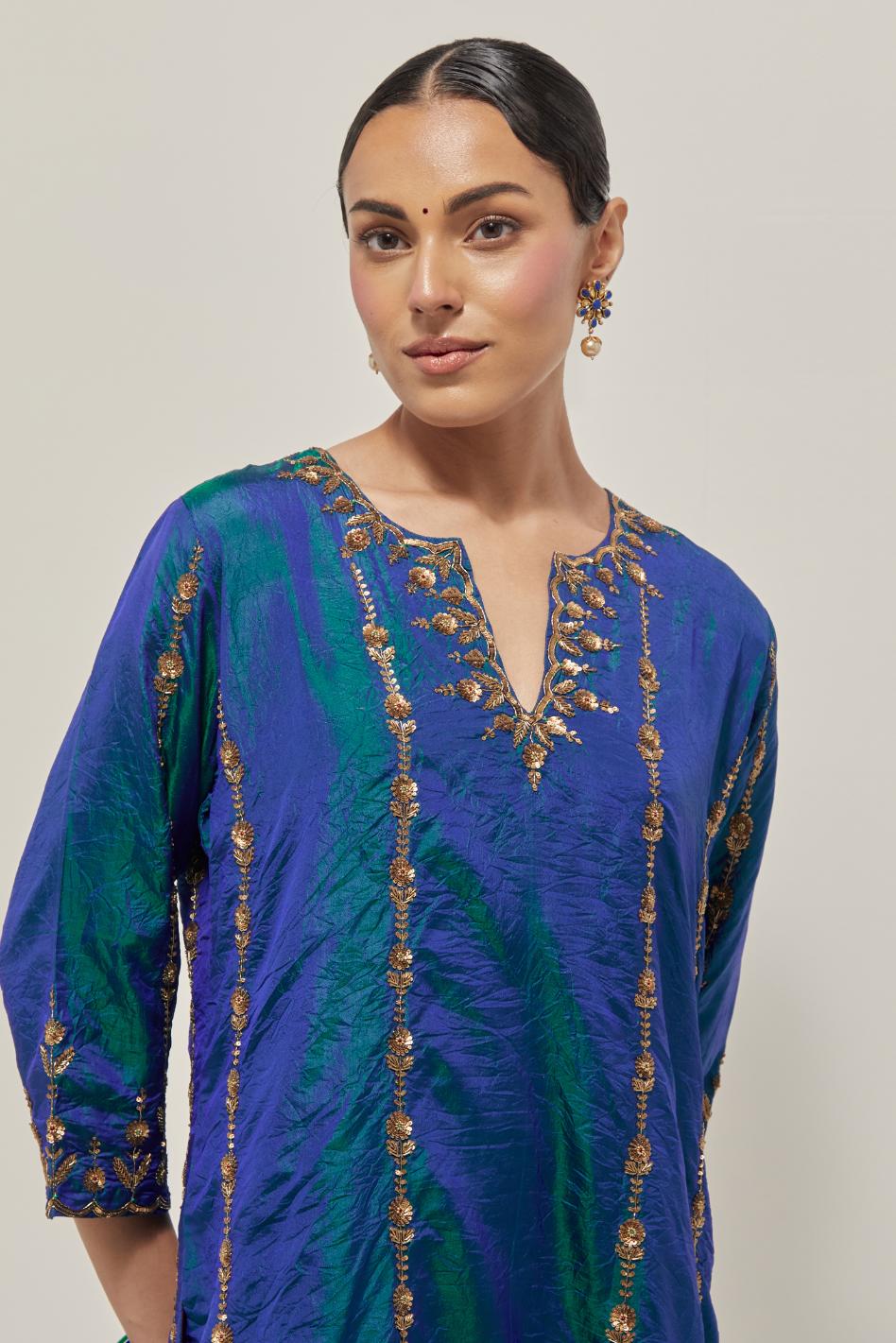 Teal Blue silk straight kurta set with round neck and slit in front. It has hand embroidered zardozi and sequins chhari stripes, all-over and heavier butas at hem, highlighted with beads.
