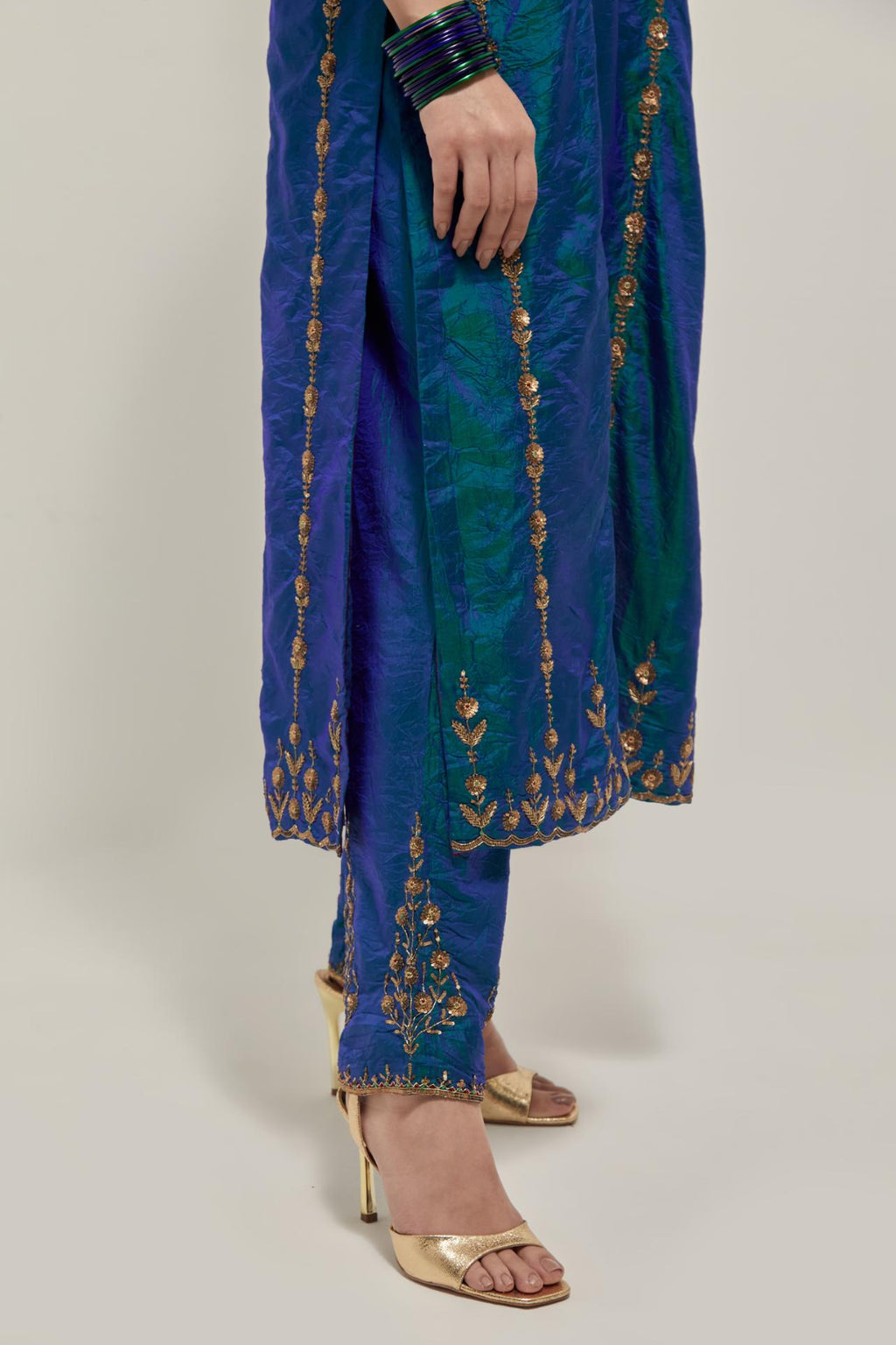 Teal Blue silk straight kurta set with round neck and slit in front. It has hand embroidered zardozi and sequins chhari stripes, all-over and heavier butas at hem, highlighted with beads.