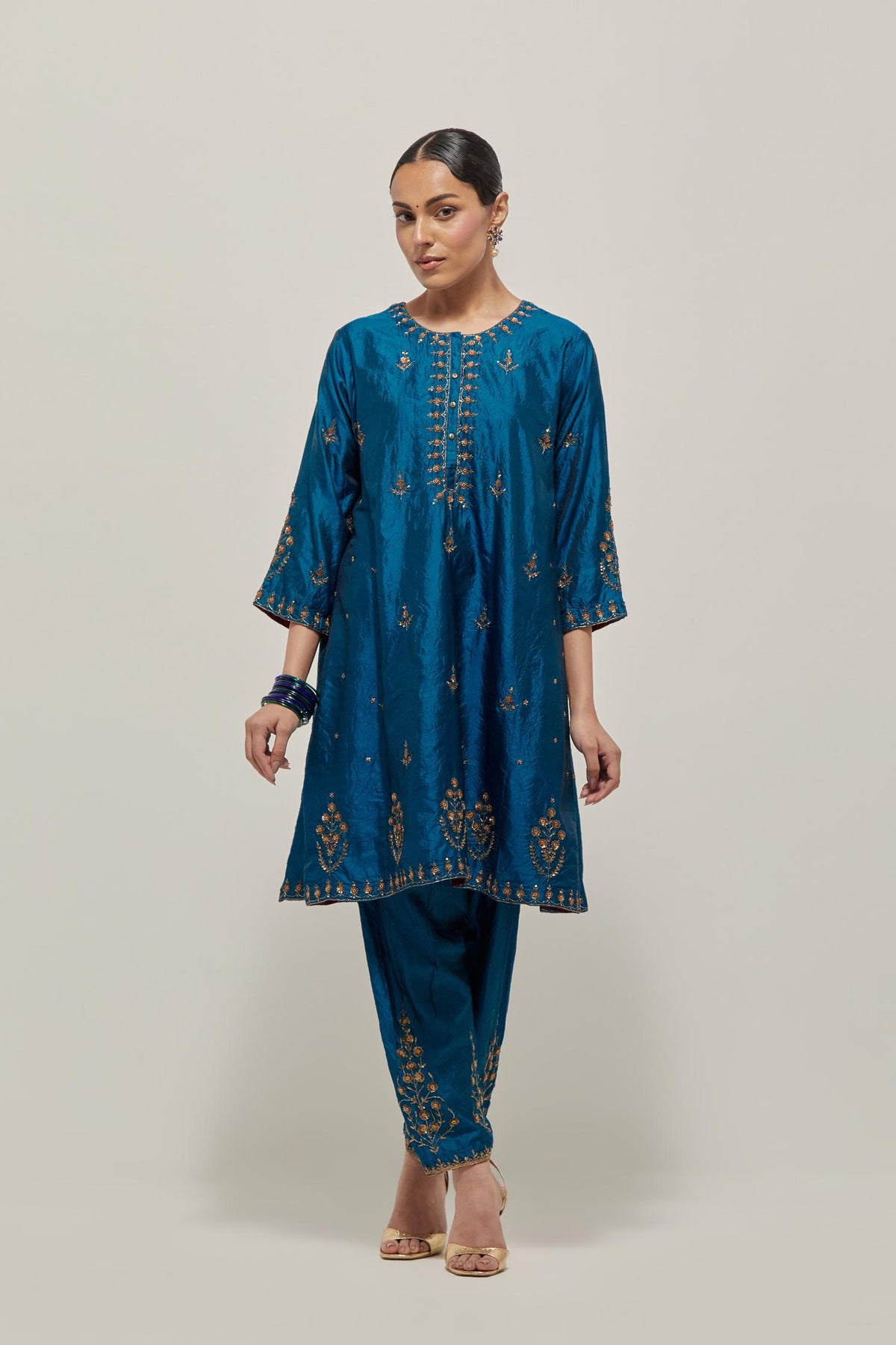 Teal double toned silk short kalidar kurta set, with hand embroidered zardozi and sequins, highlighted with beads.