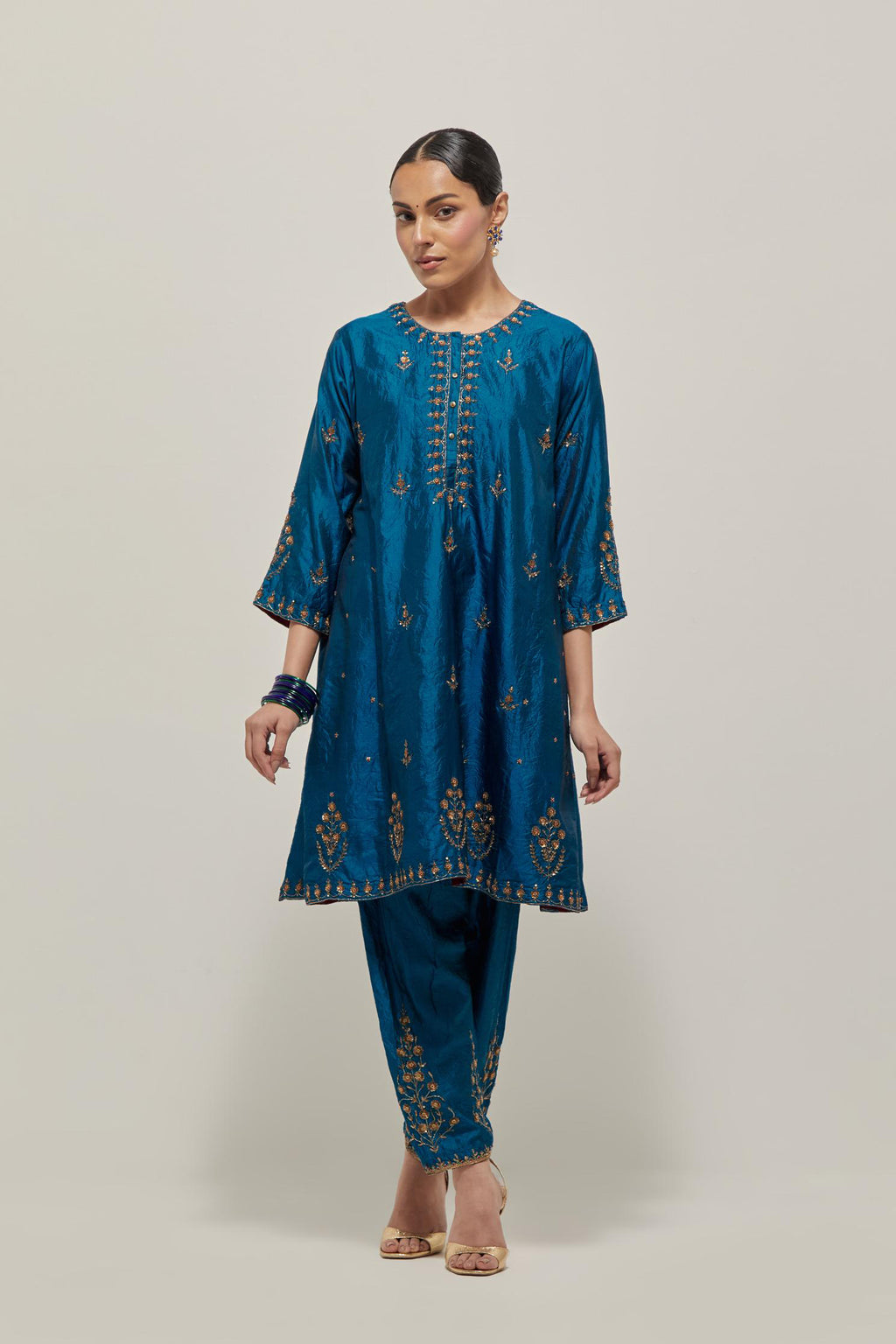 Teal double toned silk short kalidar kurta set, with hand embroidered zardozi and sequins, highlighted with beads.