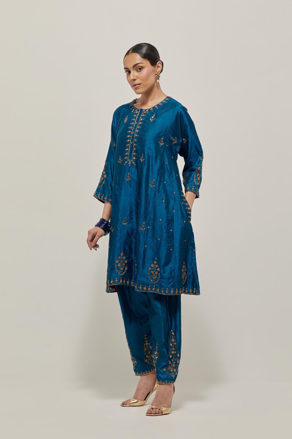 Teal double toned silk short kalidar kurta set, with hand embroidered zardozi and sequins, highlighted with beads.