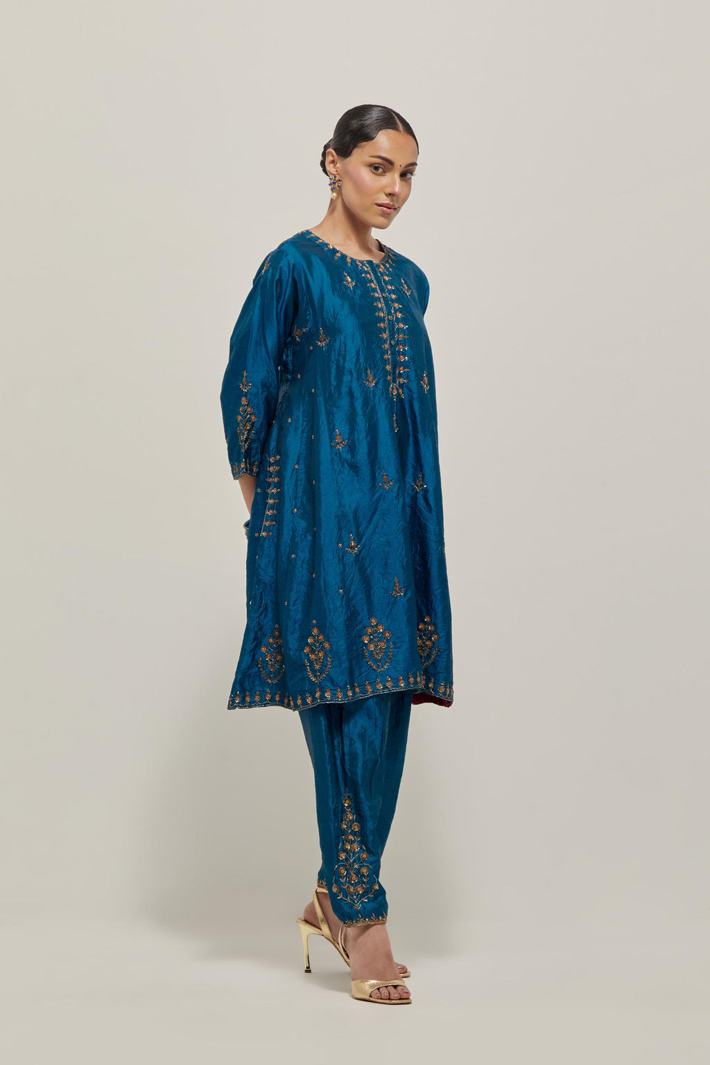 Teal double toned silk short kalidar kurta set, with hand embroidered zardozi and sequins, highlighted with beads.