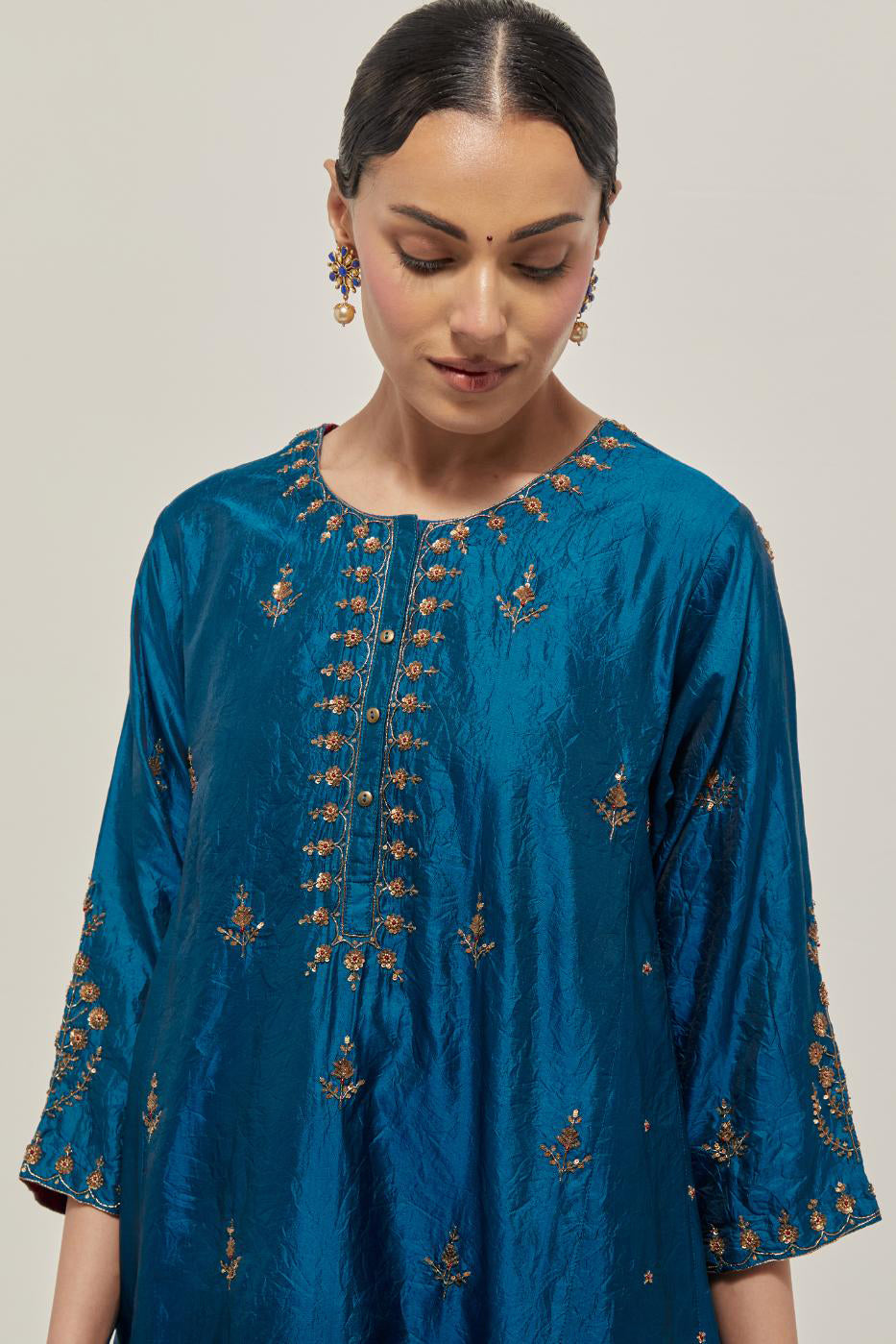 Teal double toned silk short kalidar kurta set, with hand embroidered zardozi and sequins, highlighted with beads.
