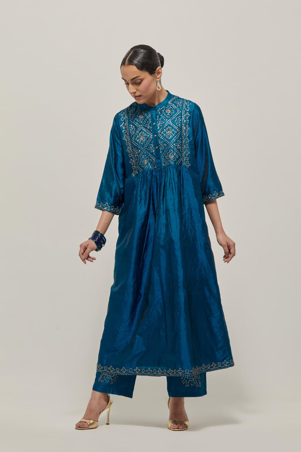 Teal Silk kurta dress set with hand embroidered sequins on bandhani inspired jaal work at neck, hem and sleeves cuff, highlighted with contrast-colored beads.