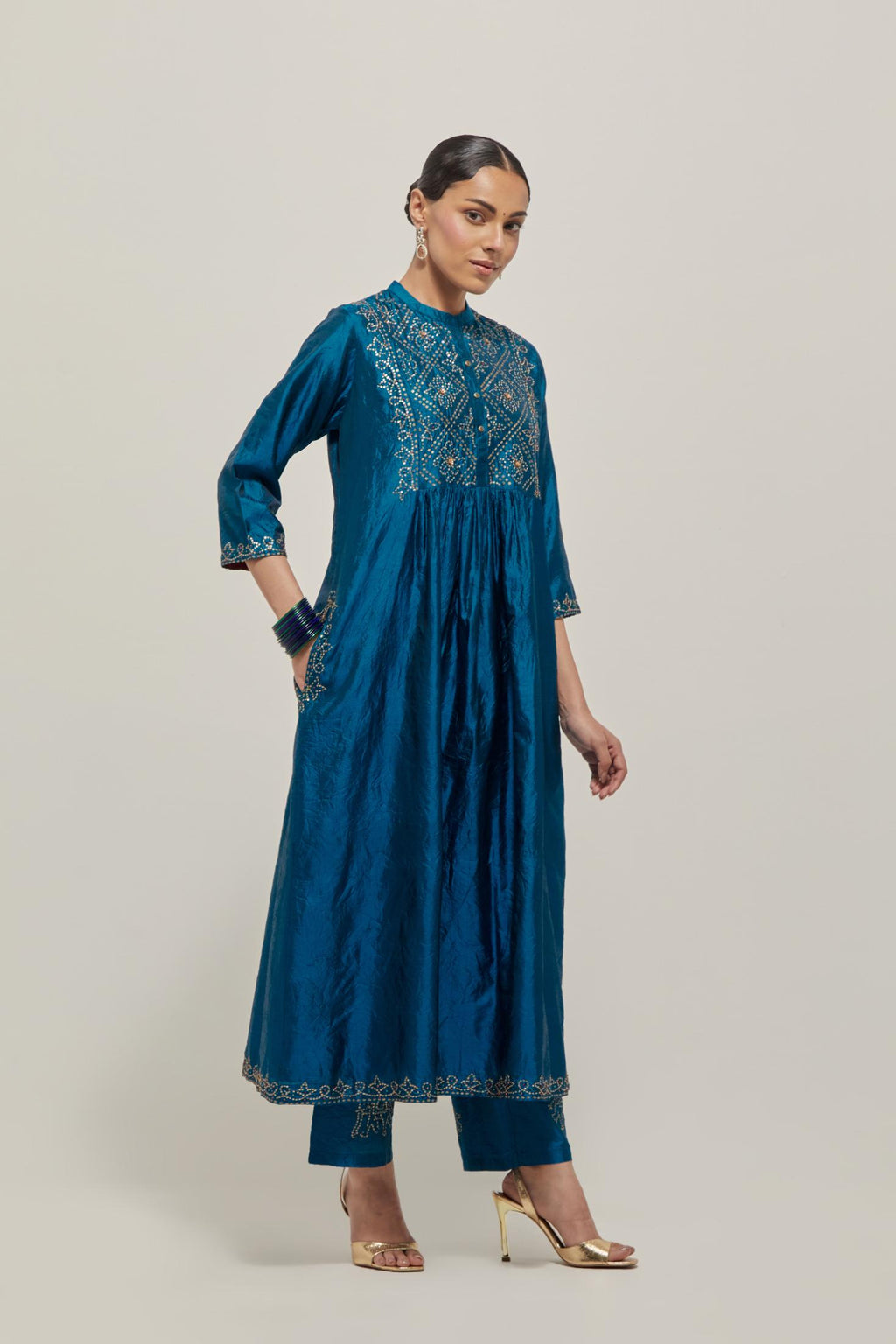 Teal Silk kurta dress set with hand embroidered sequins on bandhani inspired jaal work at neck, hem and sleeves cuff, highlighted with contrast-colored beads.