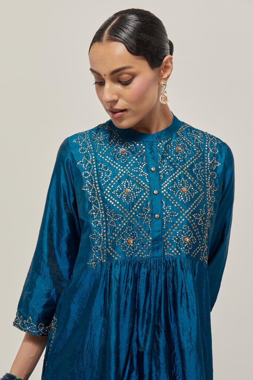 Teal Silk kurta dress set with hand embroidered sequins on bandhani inspired jaal work at neck, hem and sleeves cuff, highlighted with contrast-colored beads.