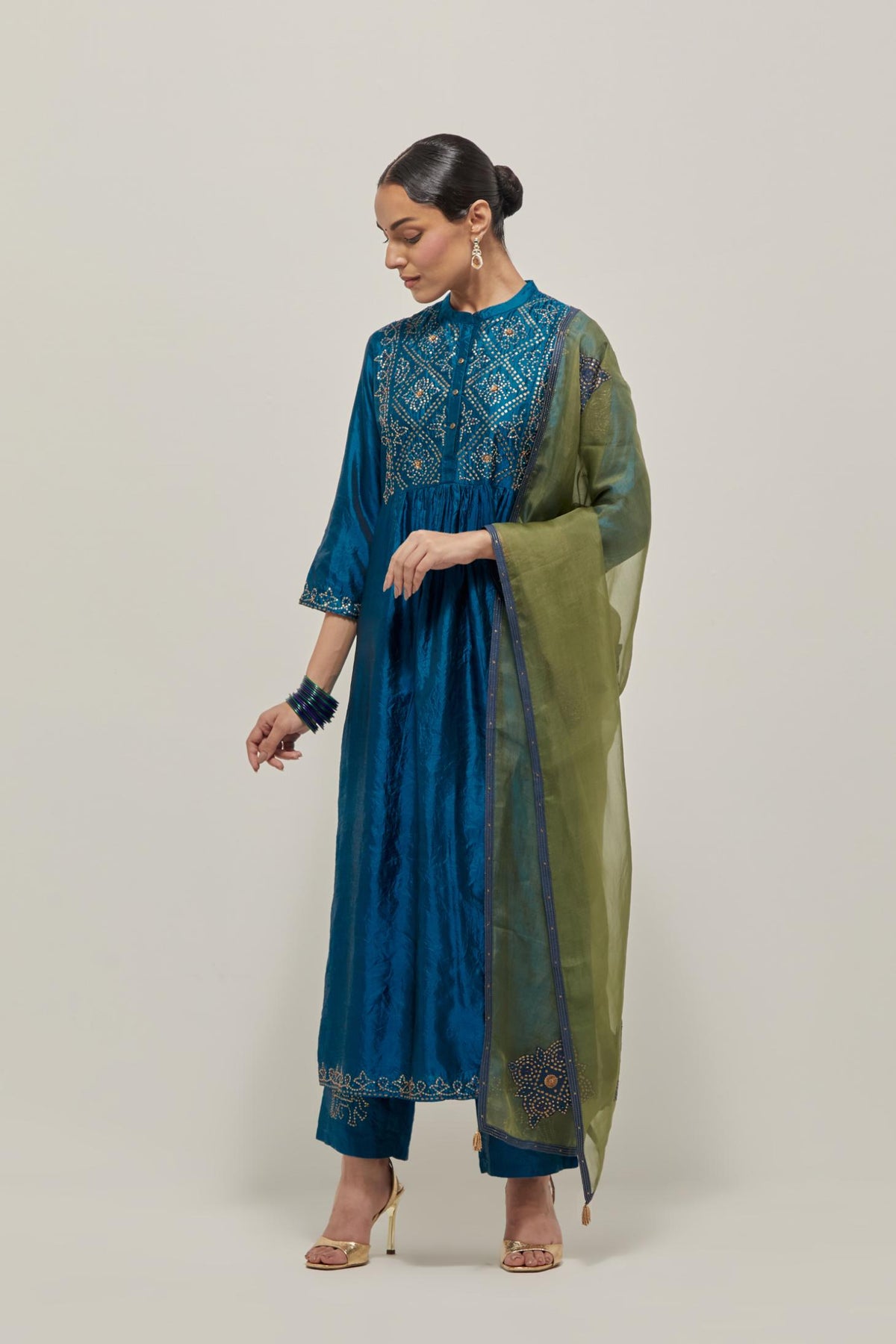 Teal Silk kurta dress set with hand embroidered sequins on bandhani inspired jaal work at neck, hem and sleeves cuff, highlighted with contrast-colored beads.