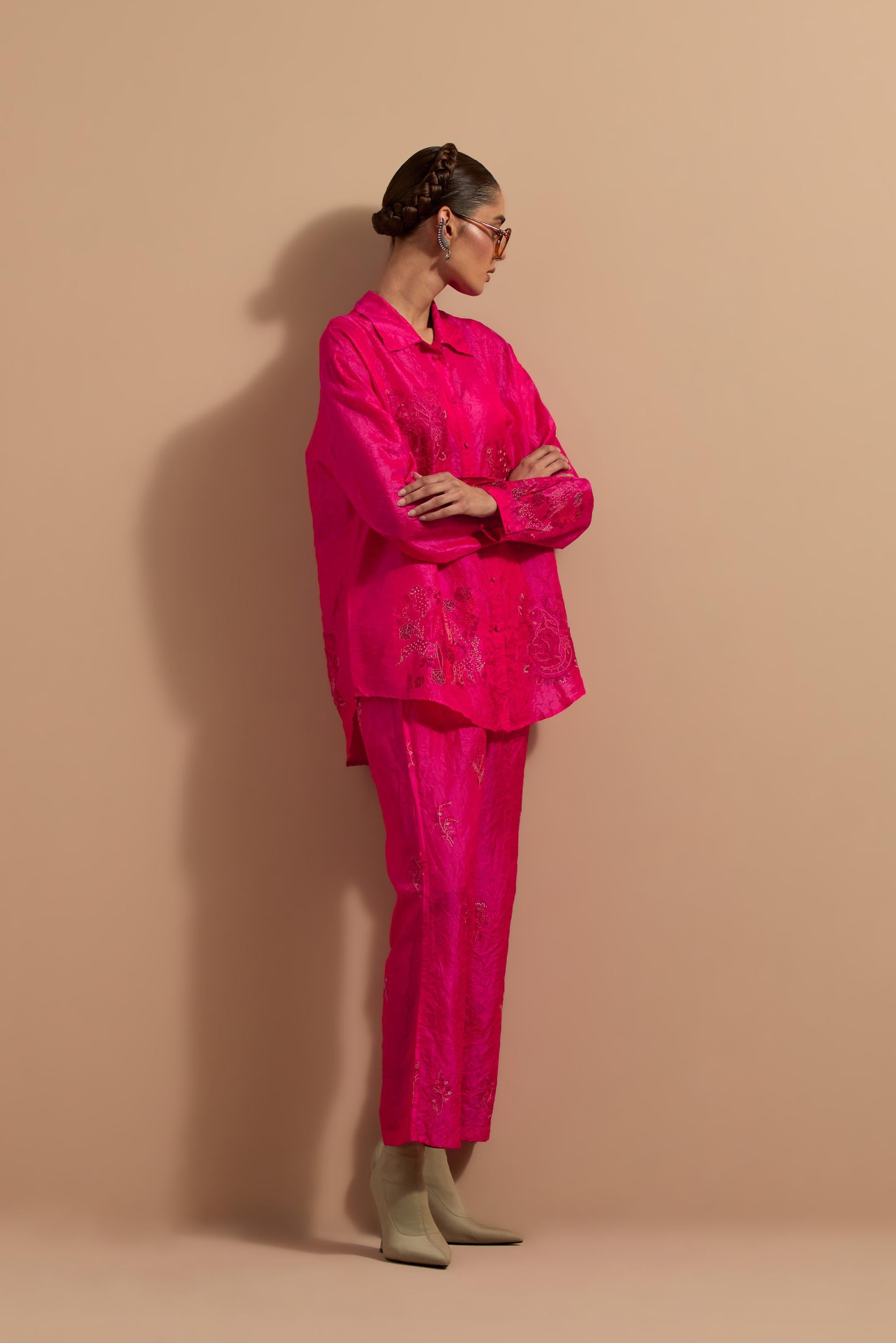 Fuchsia crushed silk hand block printed shirt, highlighted with multi colored thread embroidery, paired with Fuchsia crushed silk hand block printed pants, highlighted with multi colored thread embroidery.