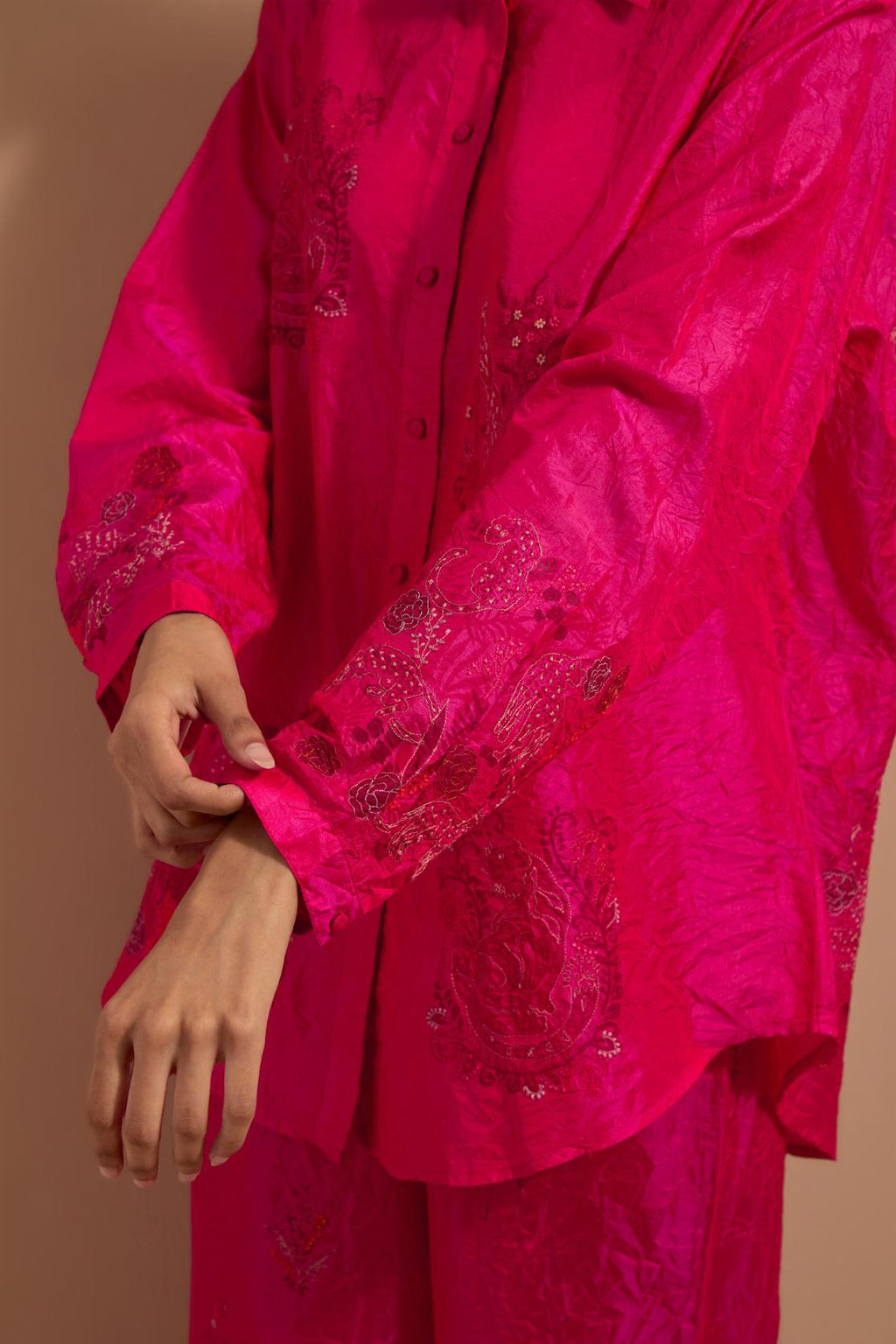 Fuchsia crushed silk hand block printed shirt, highlighted with multi colored thread embroidery, paired with Fuchsia crushed silk hand block printed pants, highlighted with multi colored thread embroidery.