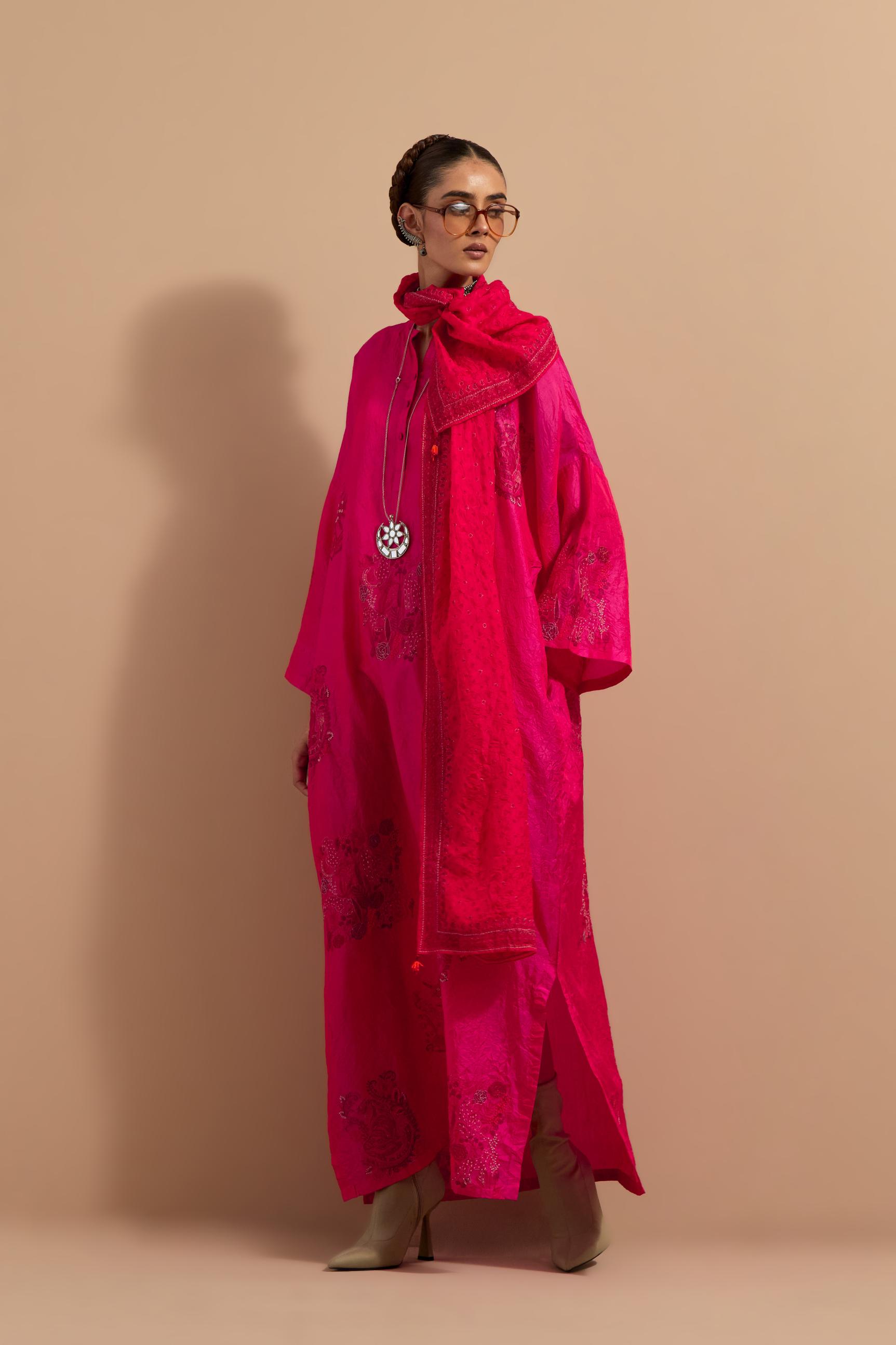 Fuchsia crushed silk hand block printed long kaftan, highlighted with multi colored thread embroidery, paired with Red hand crushed block printed silk stole with quilted embroidery and beaded tassels.