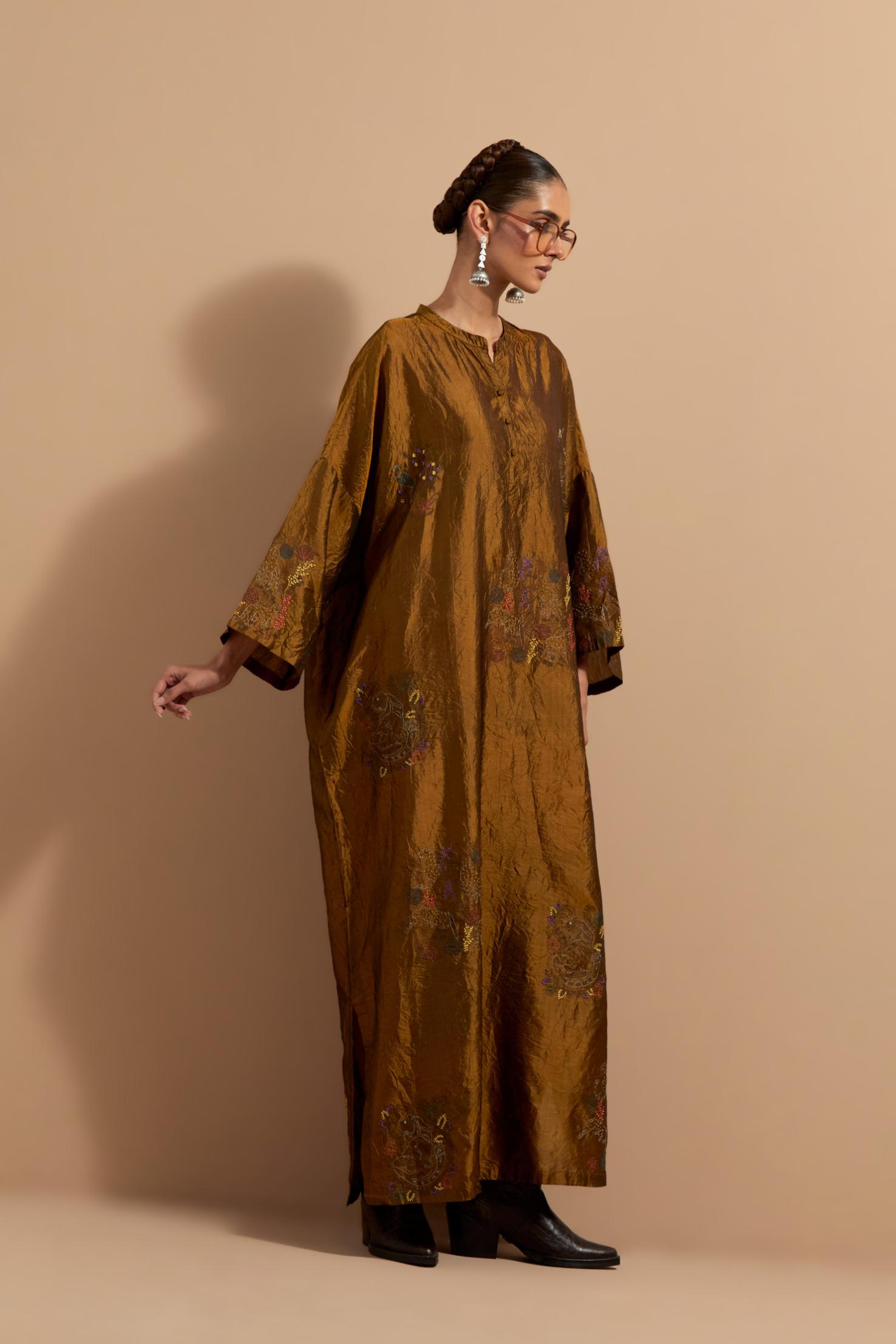 Olive crushed silk hand block printed long kaftan, highlighted with multi colored thread embroidery, paired with Red hand crushed block printed silk stole with quilted embroidery and beaded tassels.