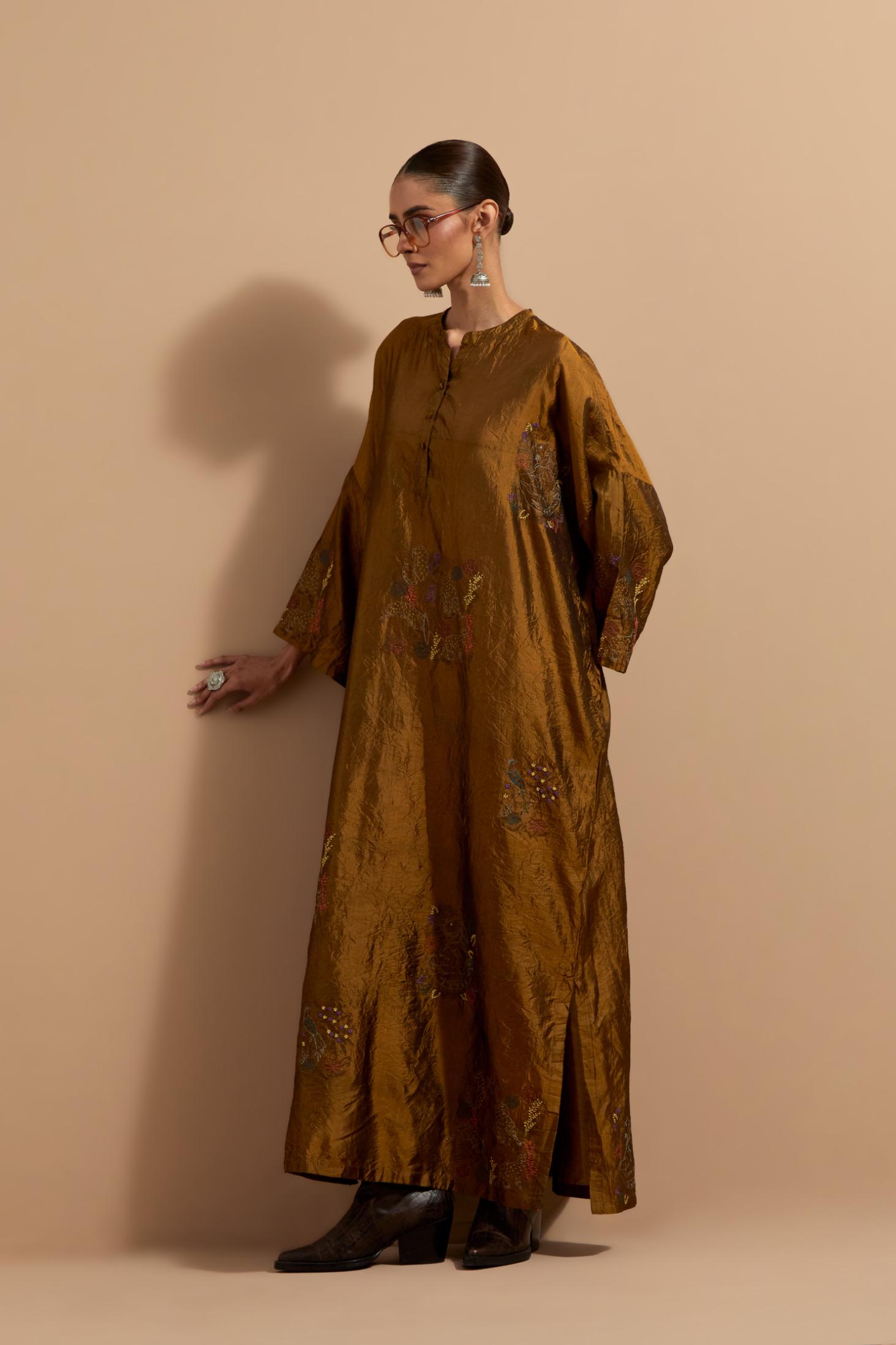 Olive crushed silk hand block printed long kaftan, highlighted with multi colored thread embroidery, paired with Red hand crushed block printed silk stole with quilted embroidery and beaded tassels.