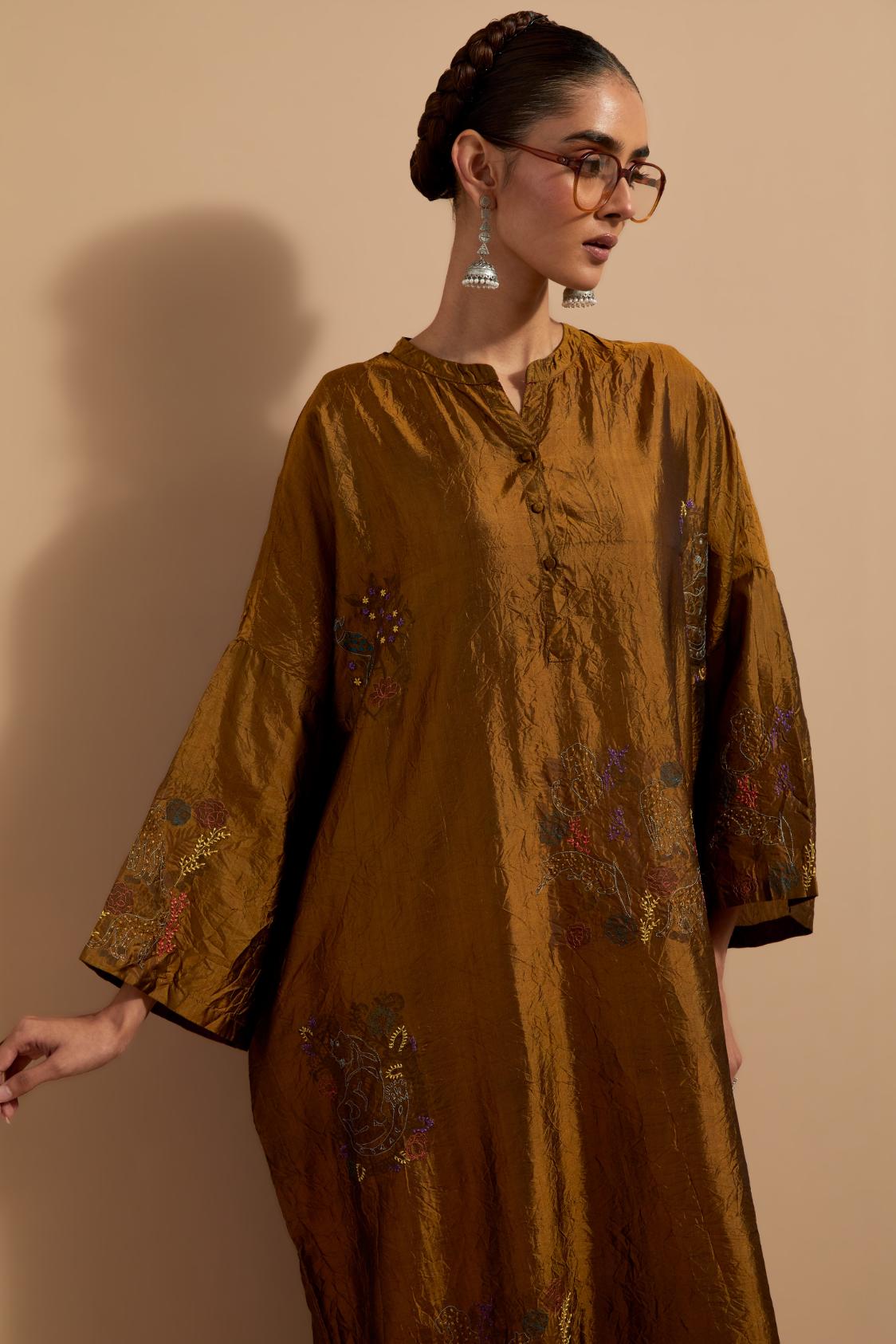 Olive crushed silk hand block printed long kaftan, highlighted with multi colored thread embroidery, paired with Red hand crushed block printed silk stole with quilted embroidery and beaded tassels.