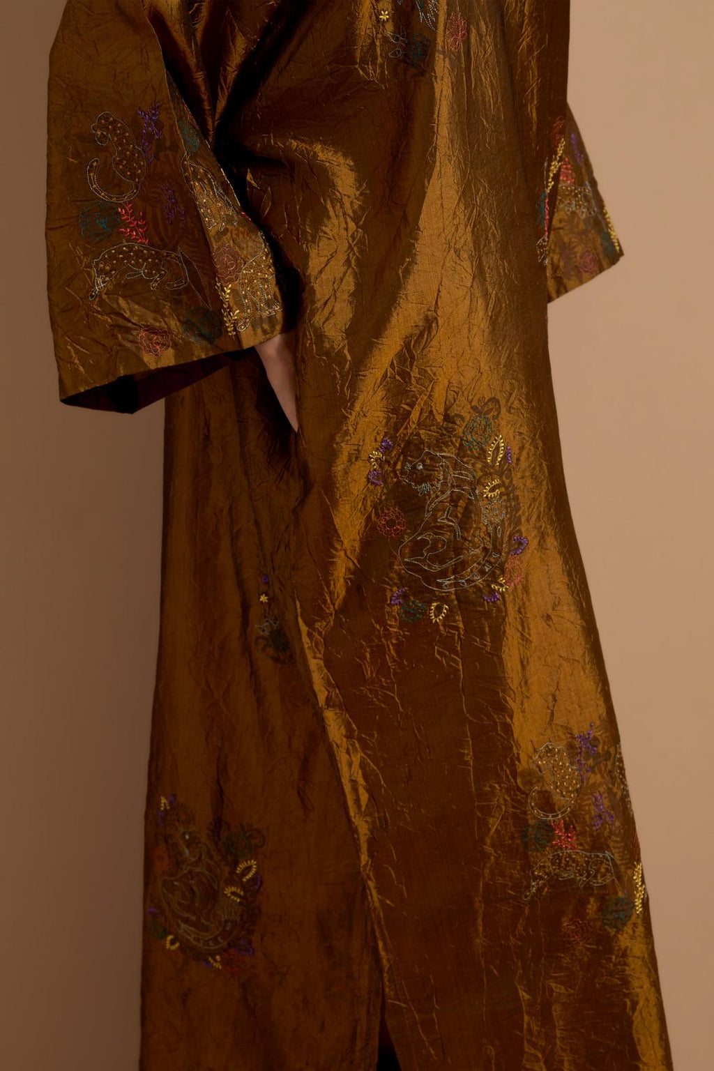 Olive crushed silk hand block printed long kaftan, highlighted with multi colored thread embroidery, paired with Red hand crushed block printed silk stole with quilted embroidery and beaded tassels.